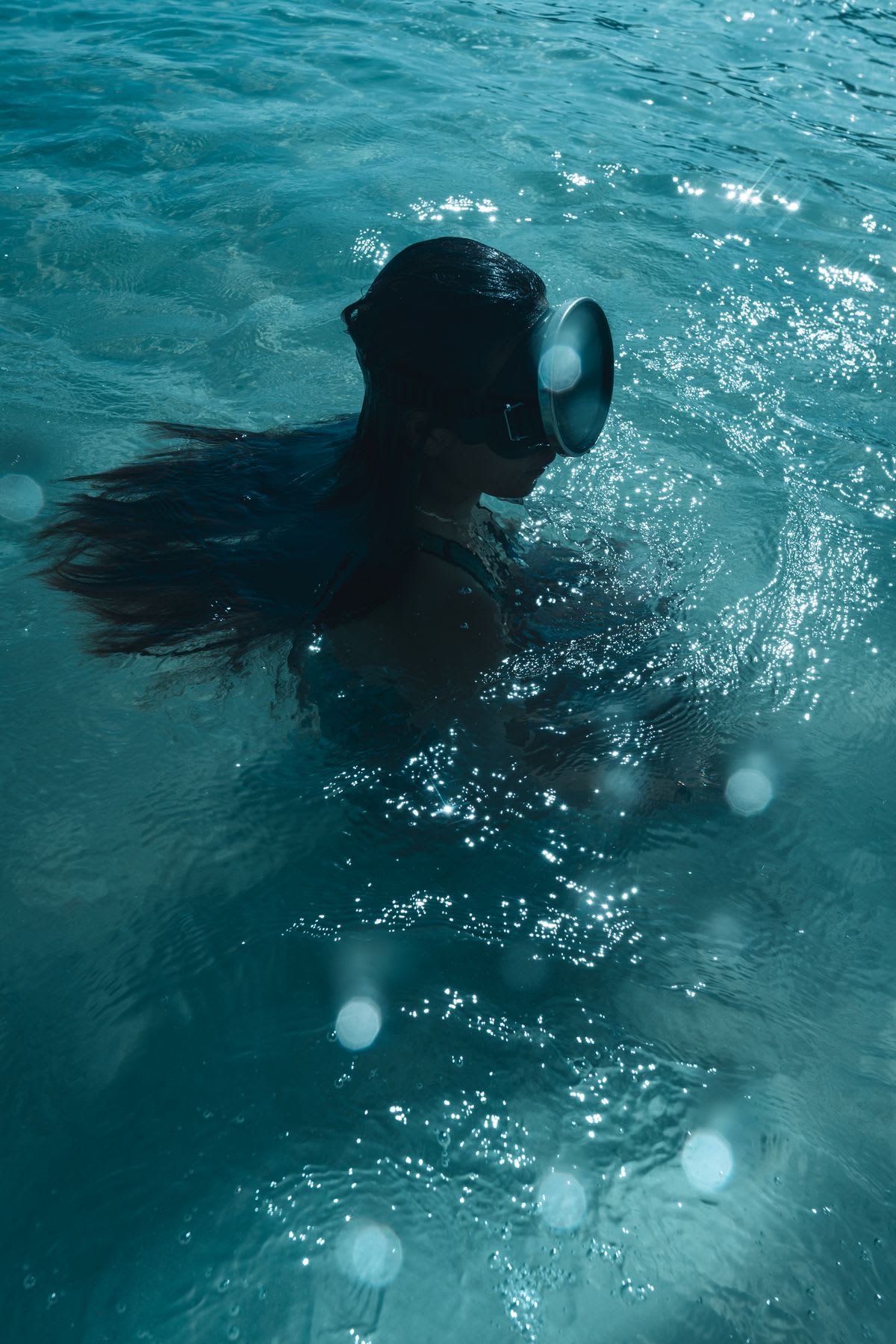 a woman with a mask on is swimming in a pool