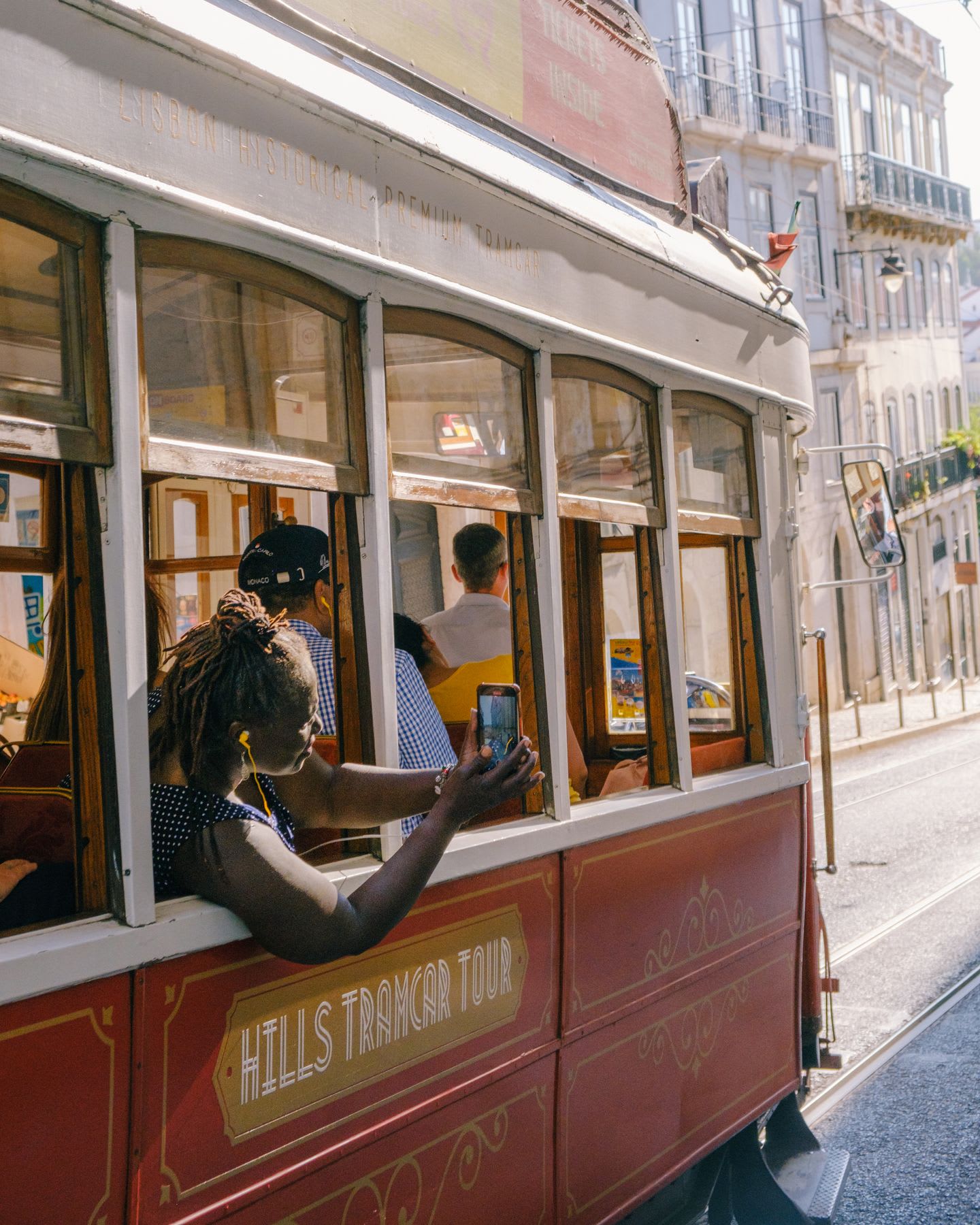 A red tramcar, part of a Hills Tramcar Tour, going through downtown Lisbon, Portugal.