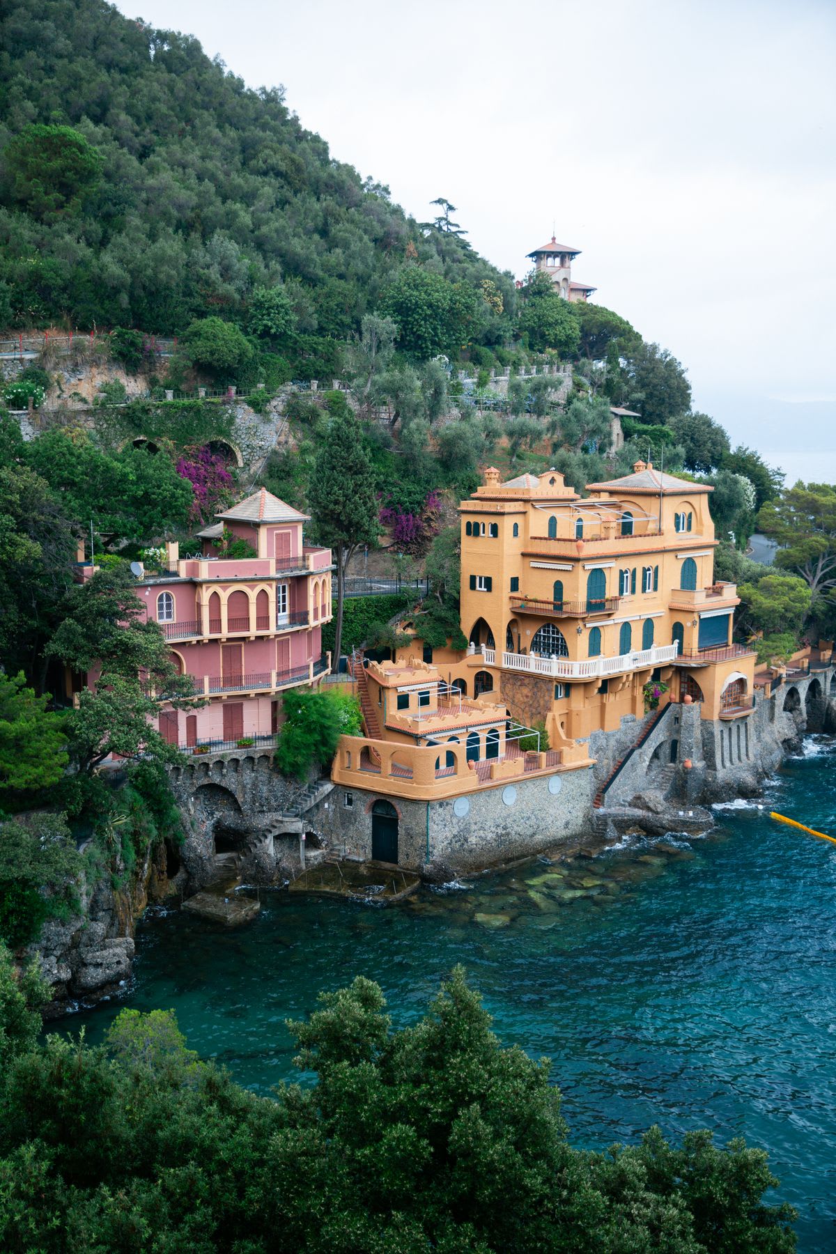 Colorful residential buildings occupy the base of a mountain on the coast.