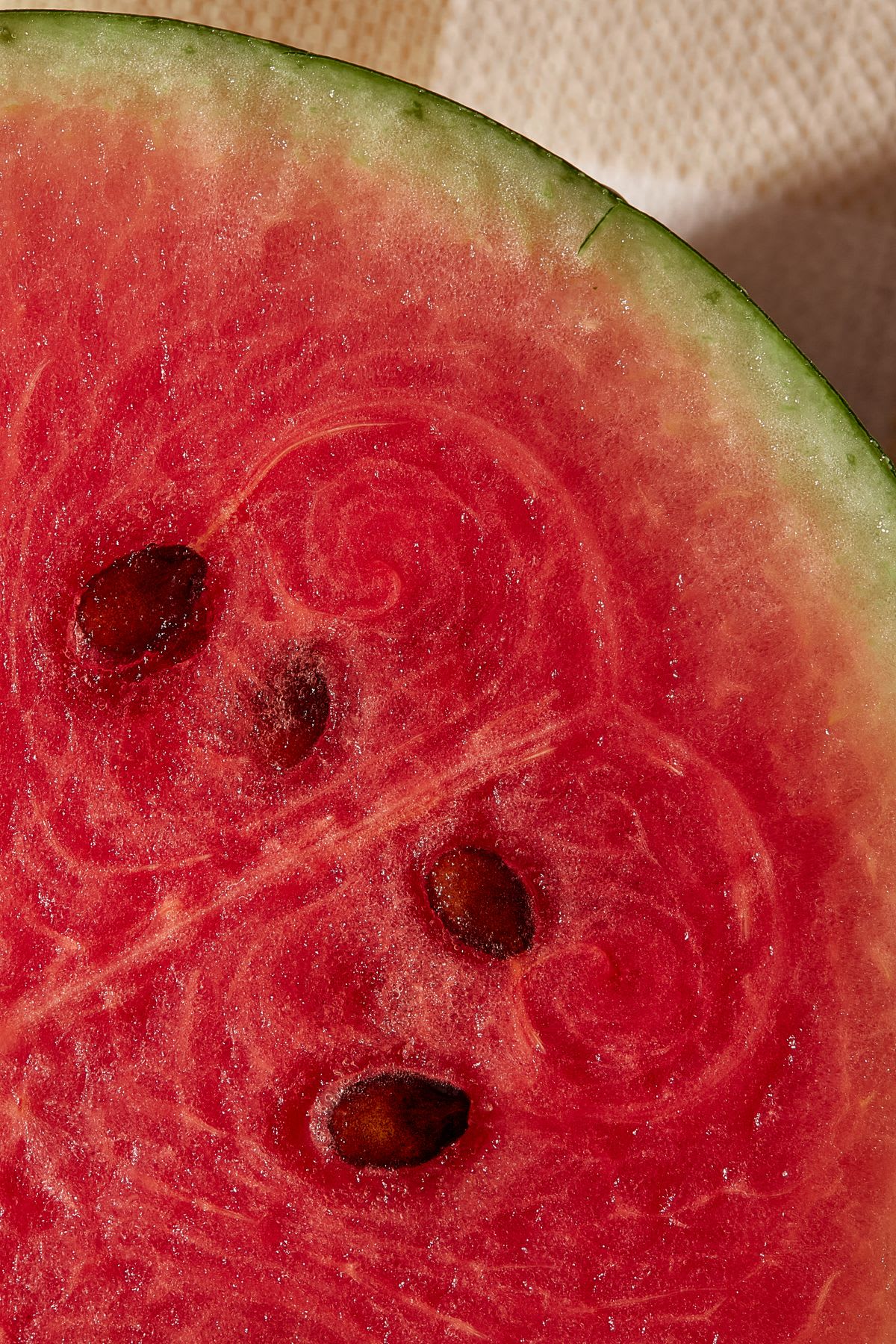 A detailed close-up shot of the vibrant red, juicy flesh of a sliced watermelon with dark seeds.