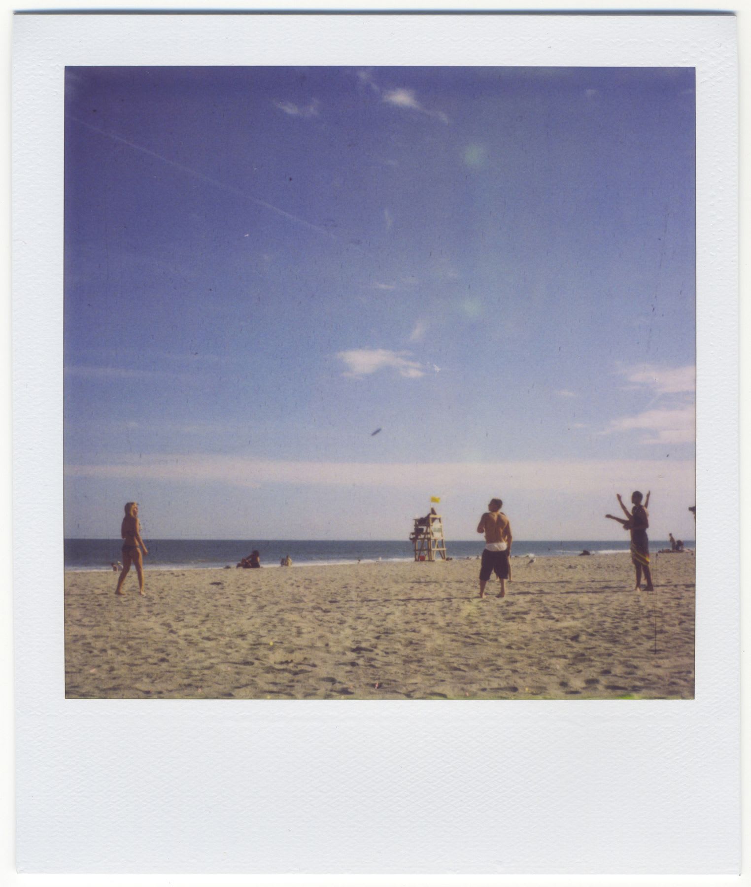 A group of friends playing with a frisbee on the beach