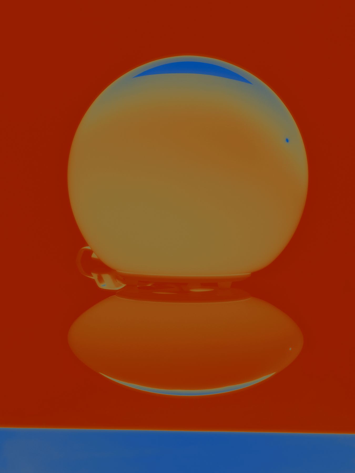 A glass orb tinted in warm orange hues rests on a reflective surface, its curved silhouette mirrored below, against a vibrant red background.