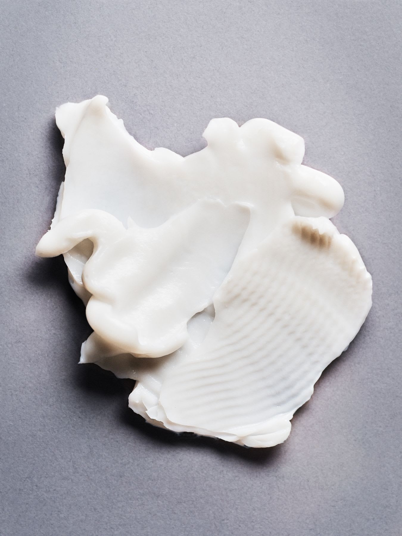 A white cream spread on a gray surface.