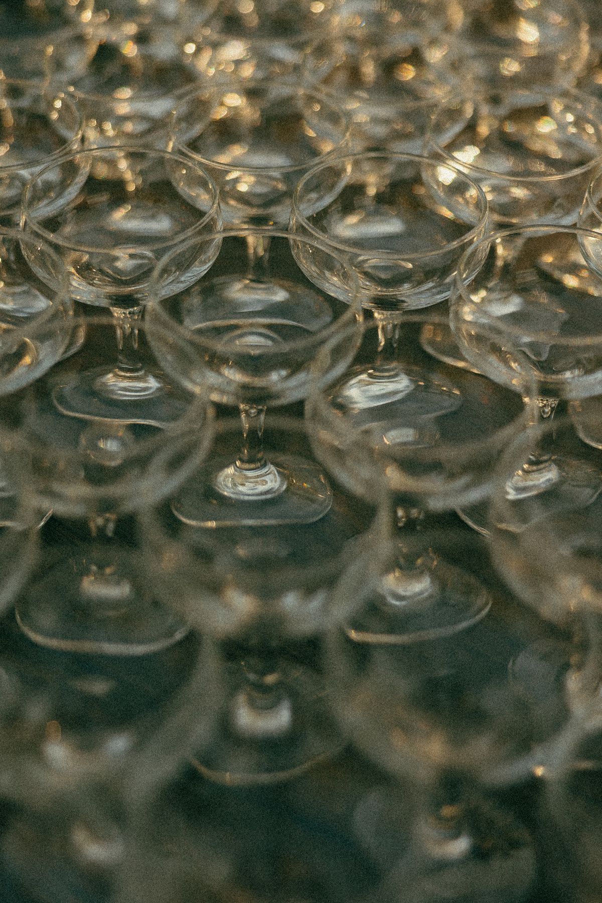 empty champagne glasses are set up with the rims touching on a table