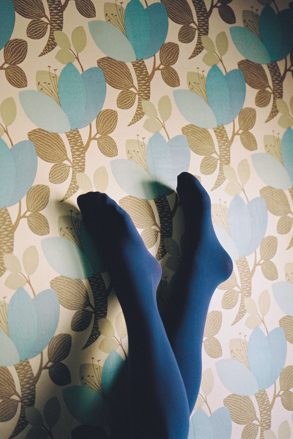 A person modeling some socks in a room