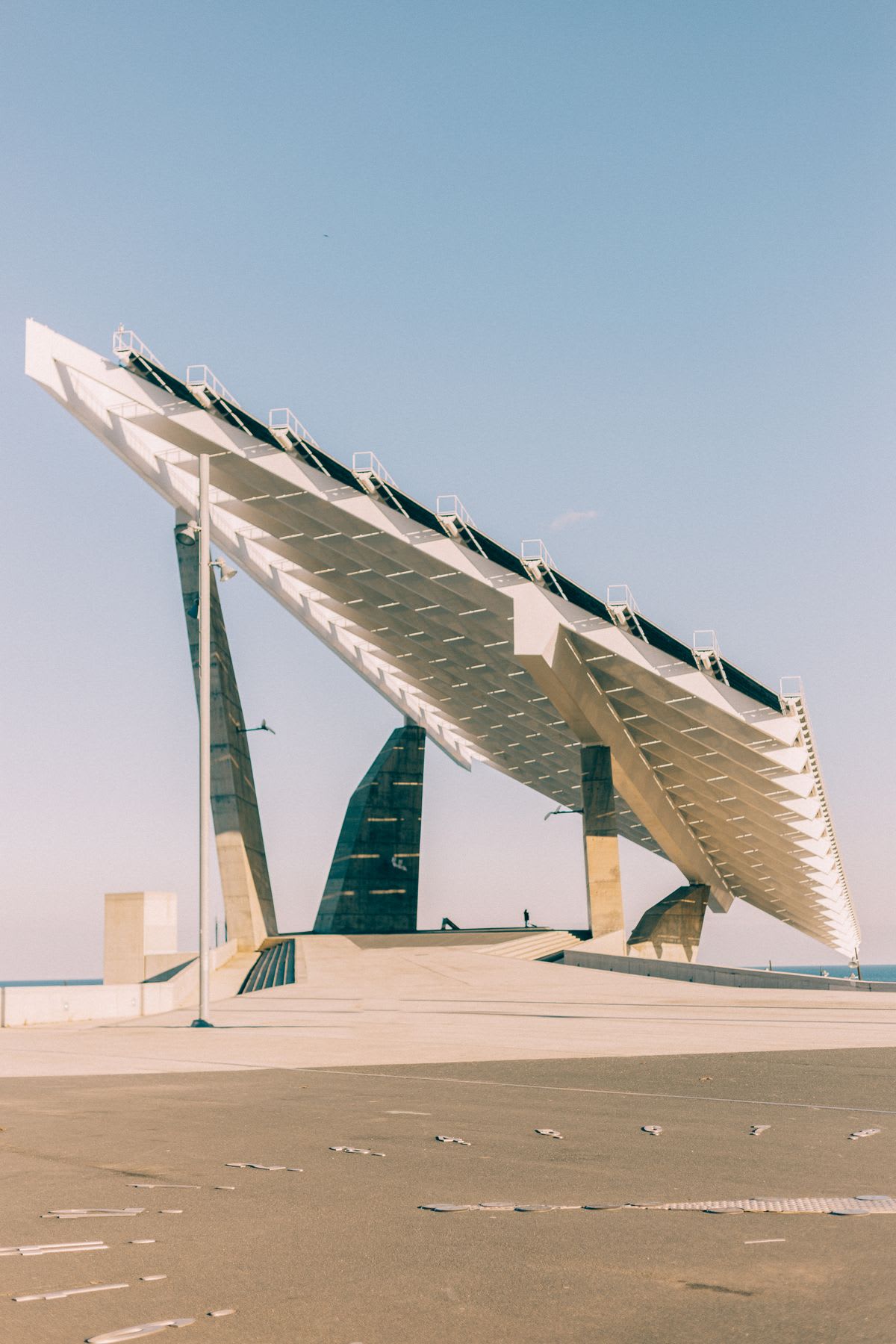 a tall building with exterior design is on a sandy beach