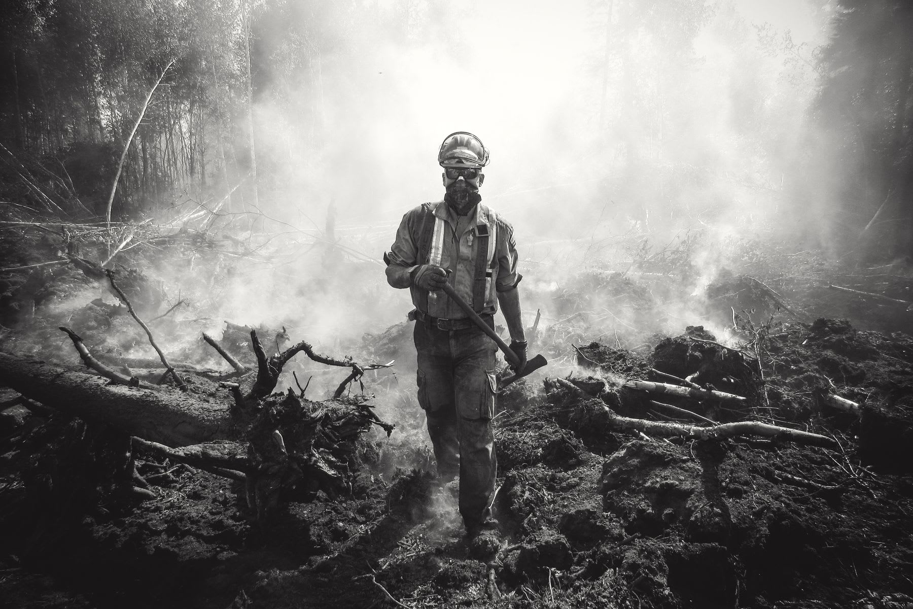 Man with an ax in a destroyed forest landscape