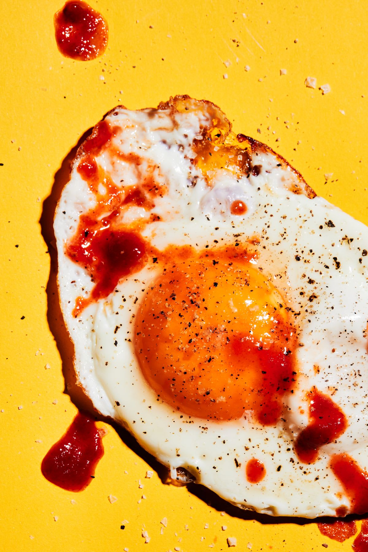 a piece of fried egg on a yellow surface