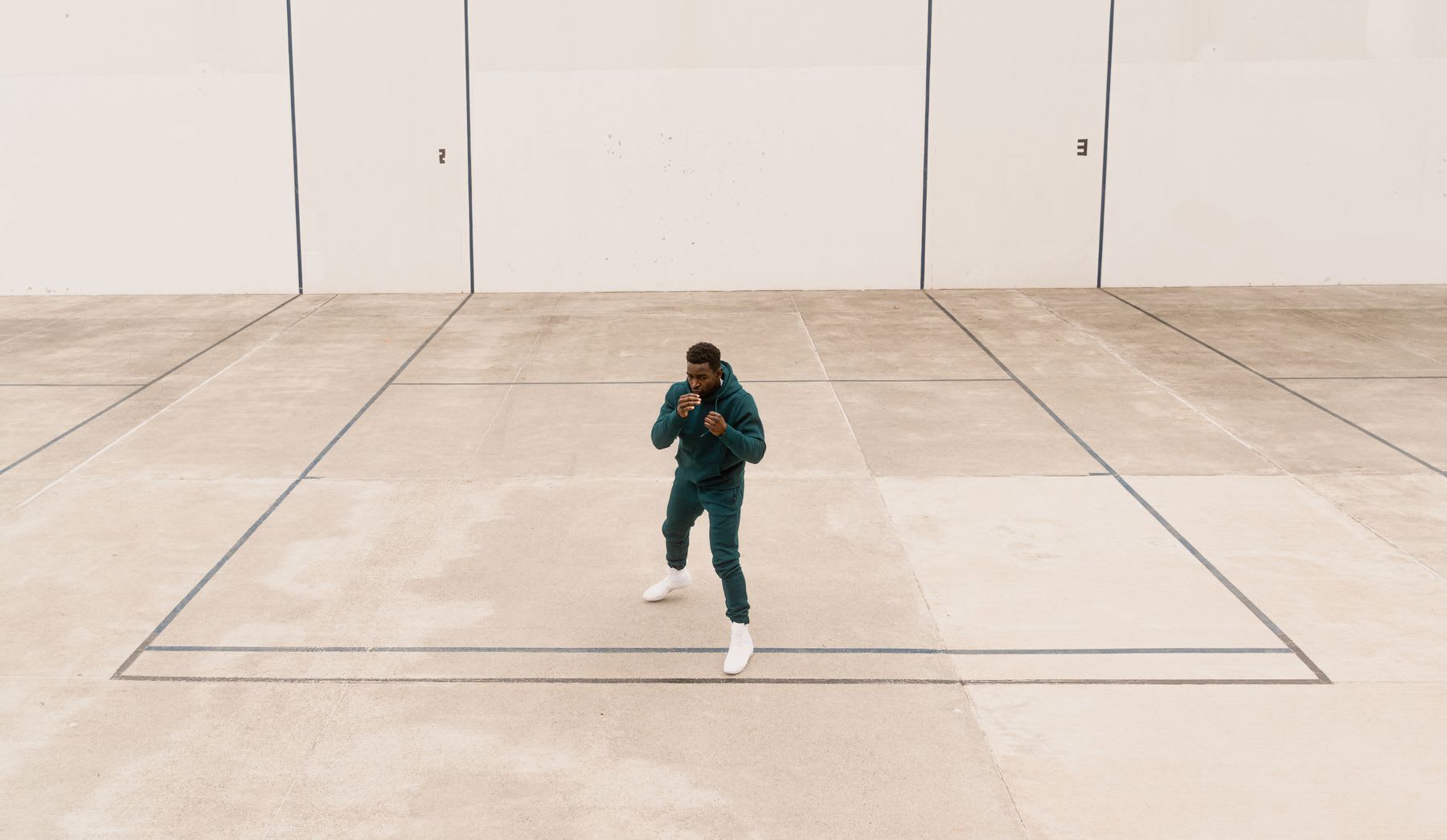 Model with sweater in fighting position indoors