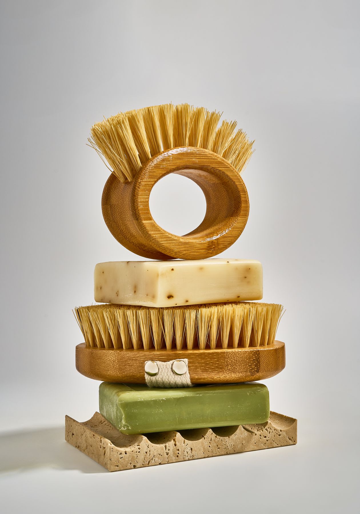 Different kinds of brushes and soaps on top of each other in a tower formation.