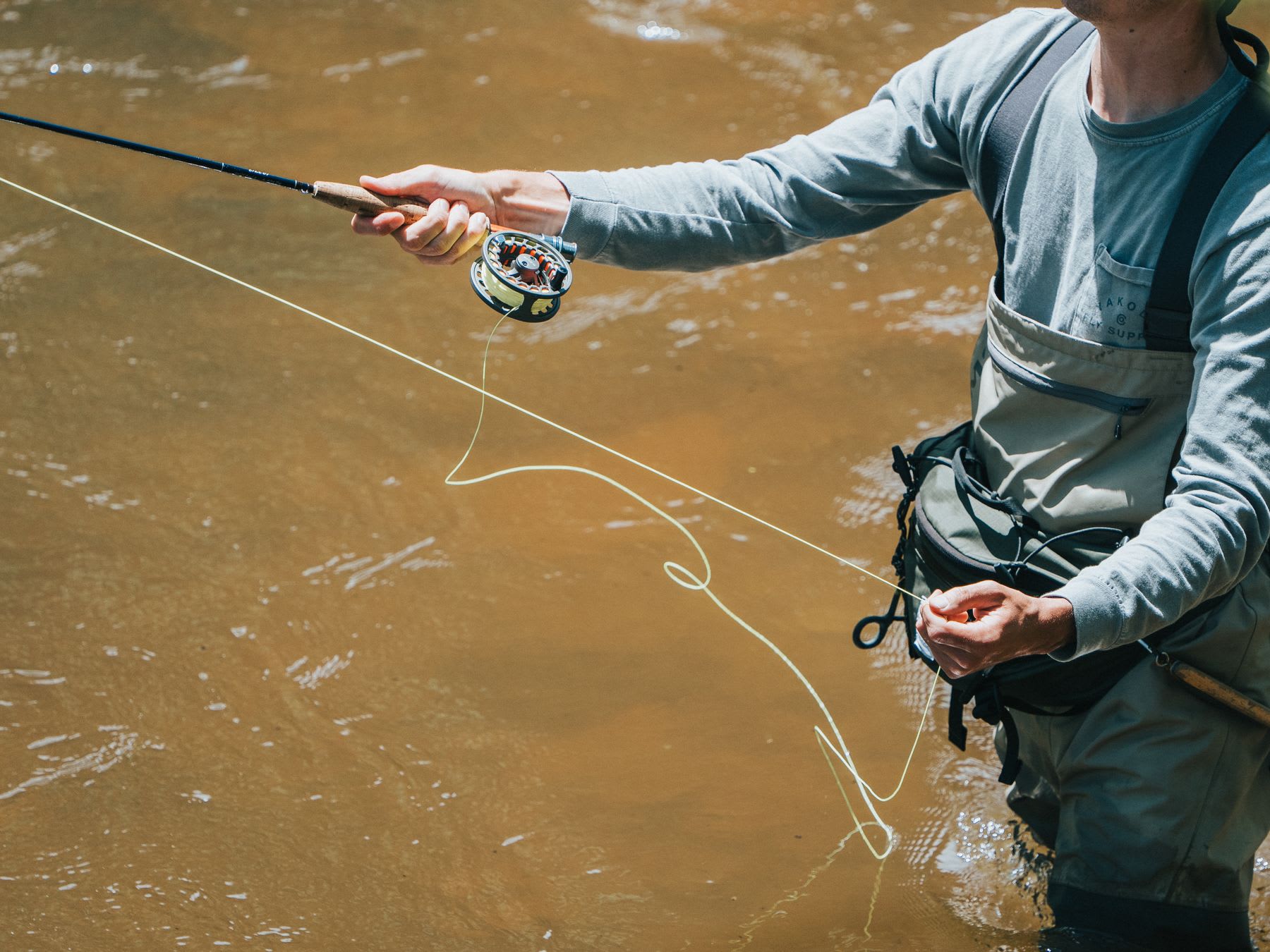 A fisherman tightens his fishing line.