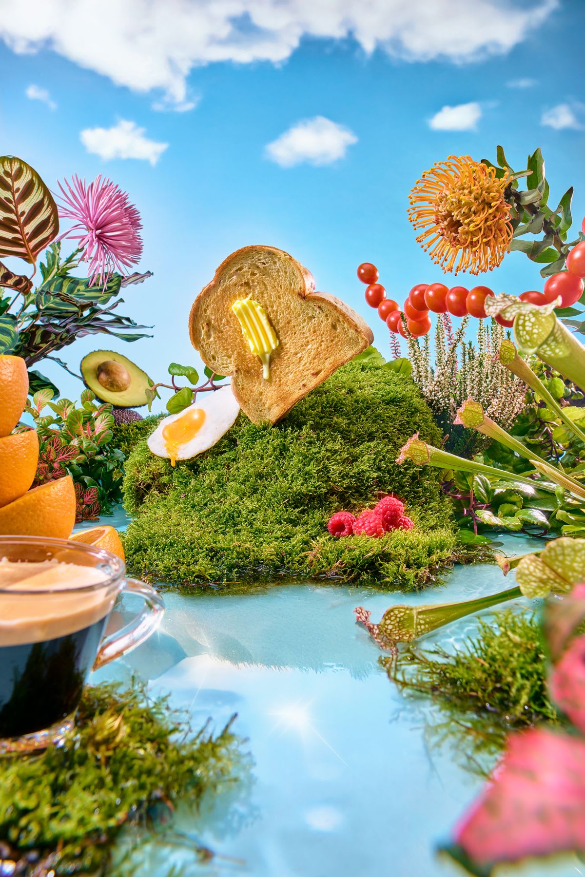 Scene with a slice of bread with butter floating on a mound of moss, surrounded by various natural elements and food.