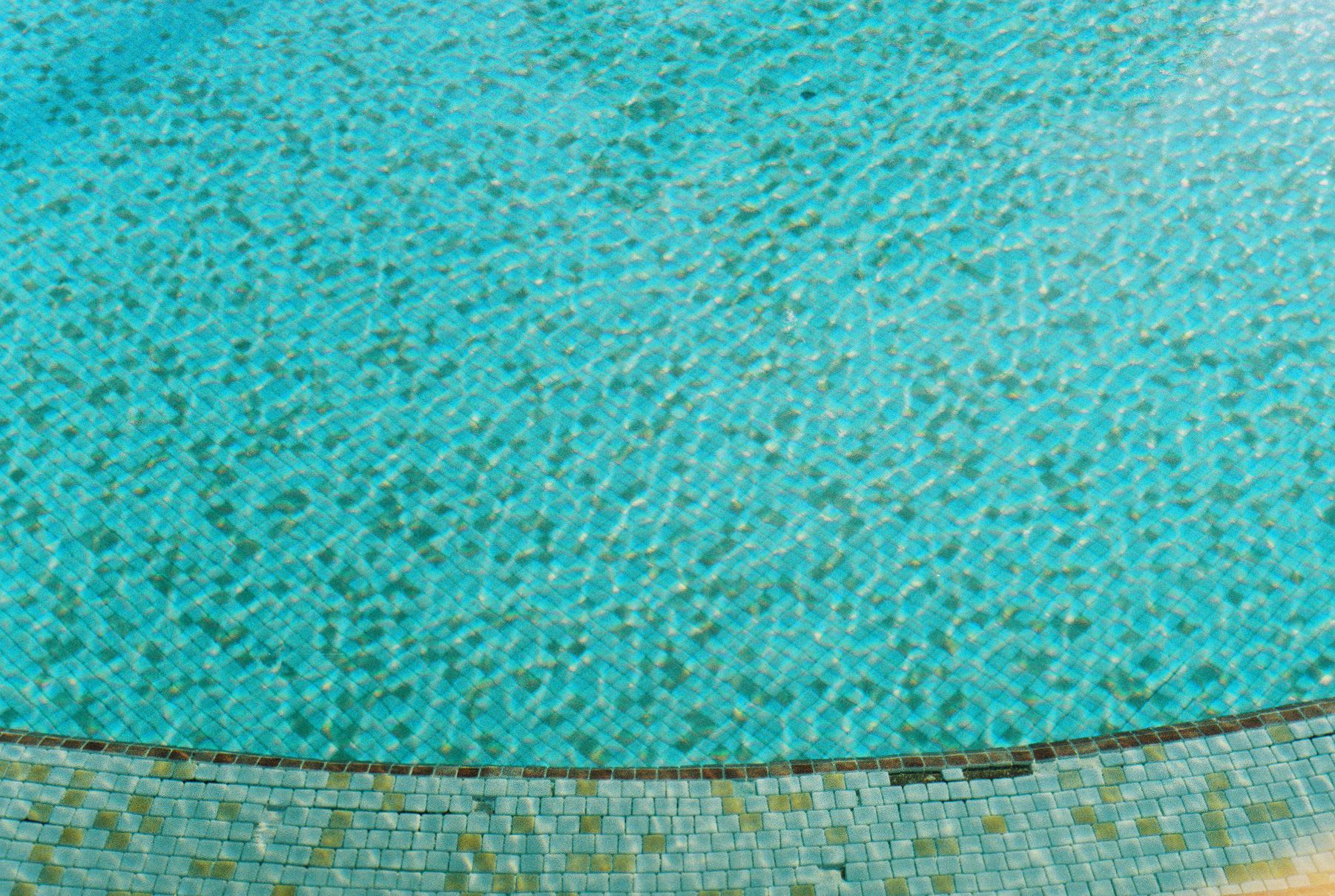 a large swimming pool with tiled floor