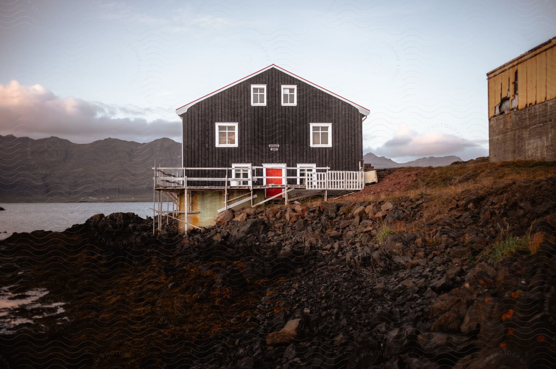 A wooden house on the beach coast at dusk.