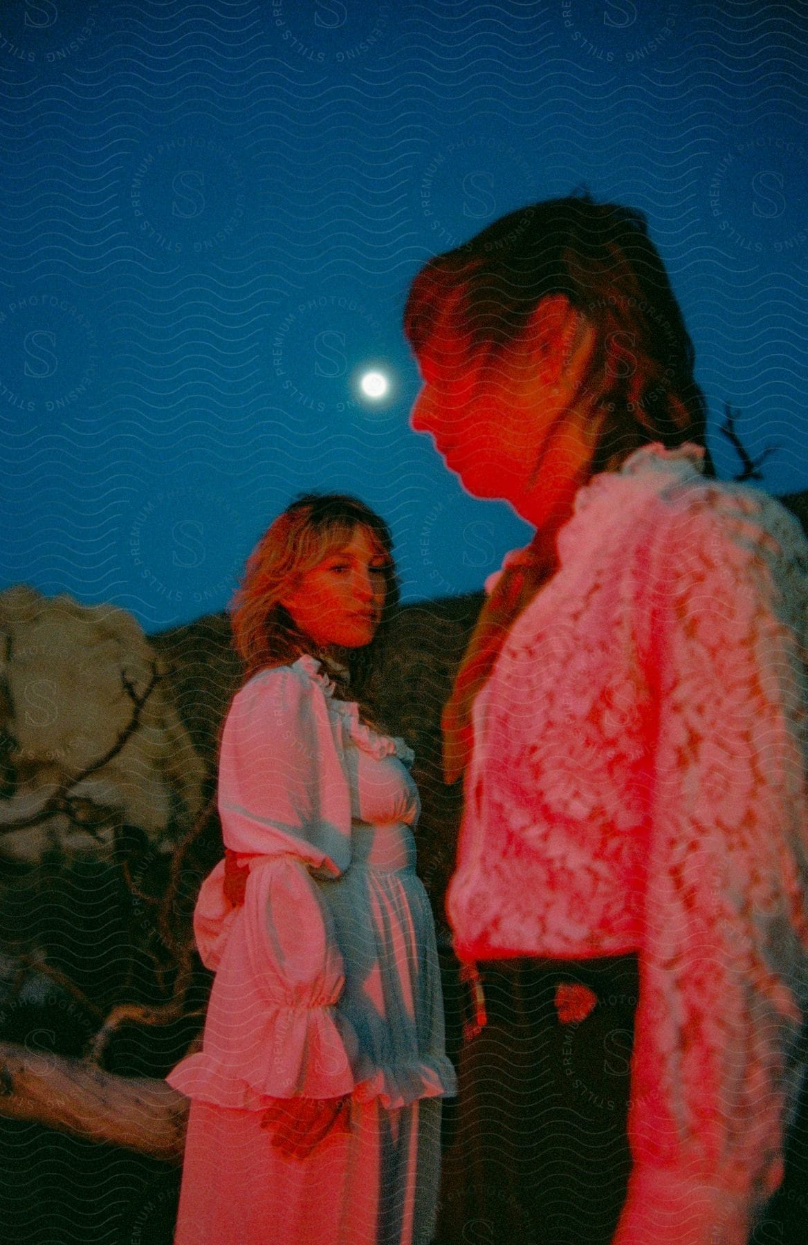 Two young women illuminated by the light of the full moon.