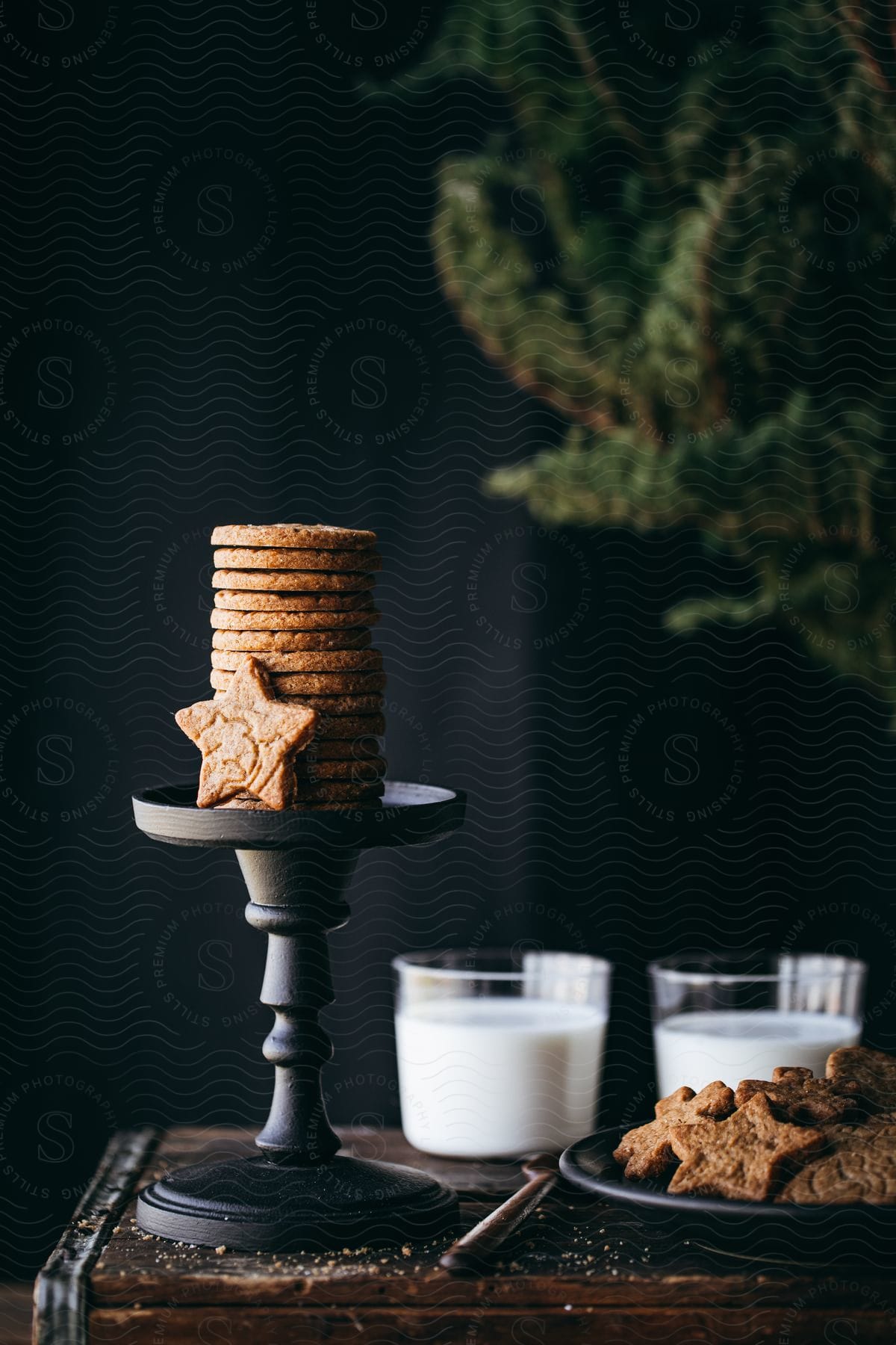 Cookies on a table with glasses of milk.