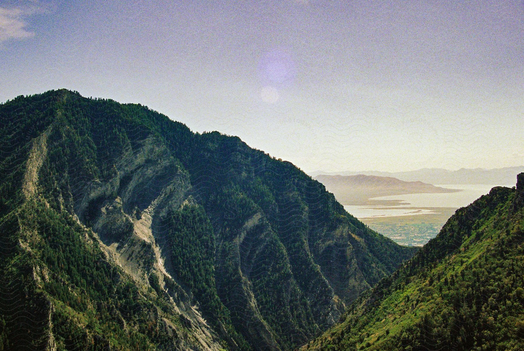 Forested mountains stand under a cloudy sky