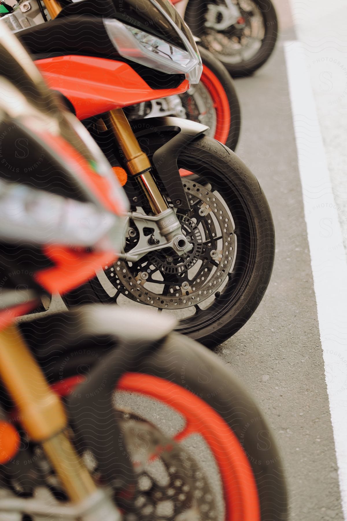 Motorcycles with their front wheels lined up on a street