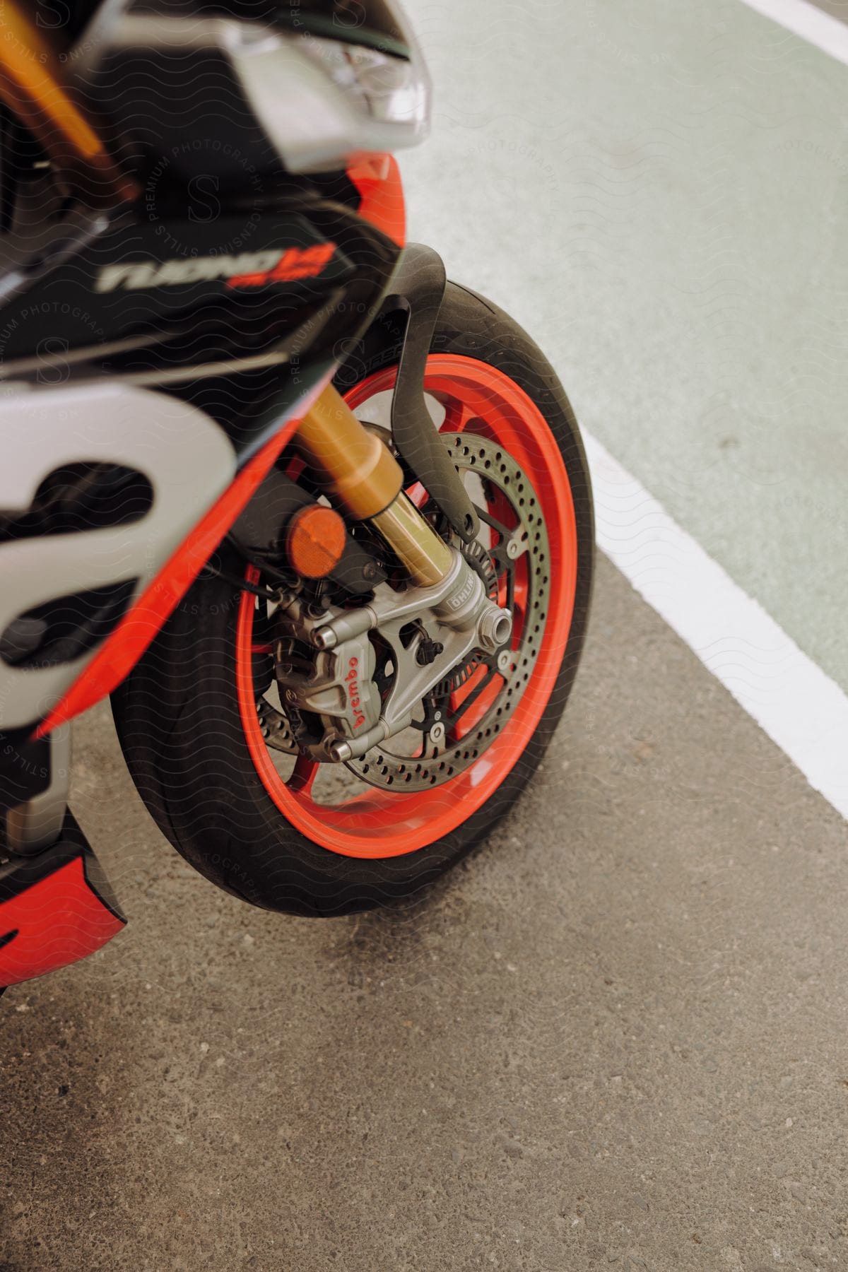 motorcycle tire with orange rims on pavement