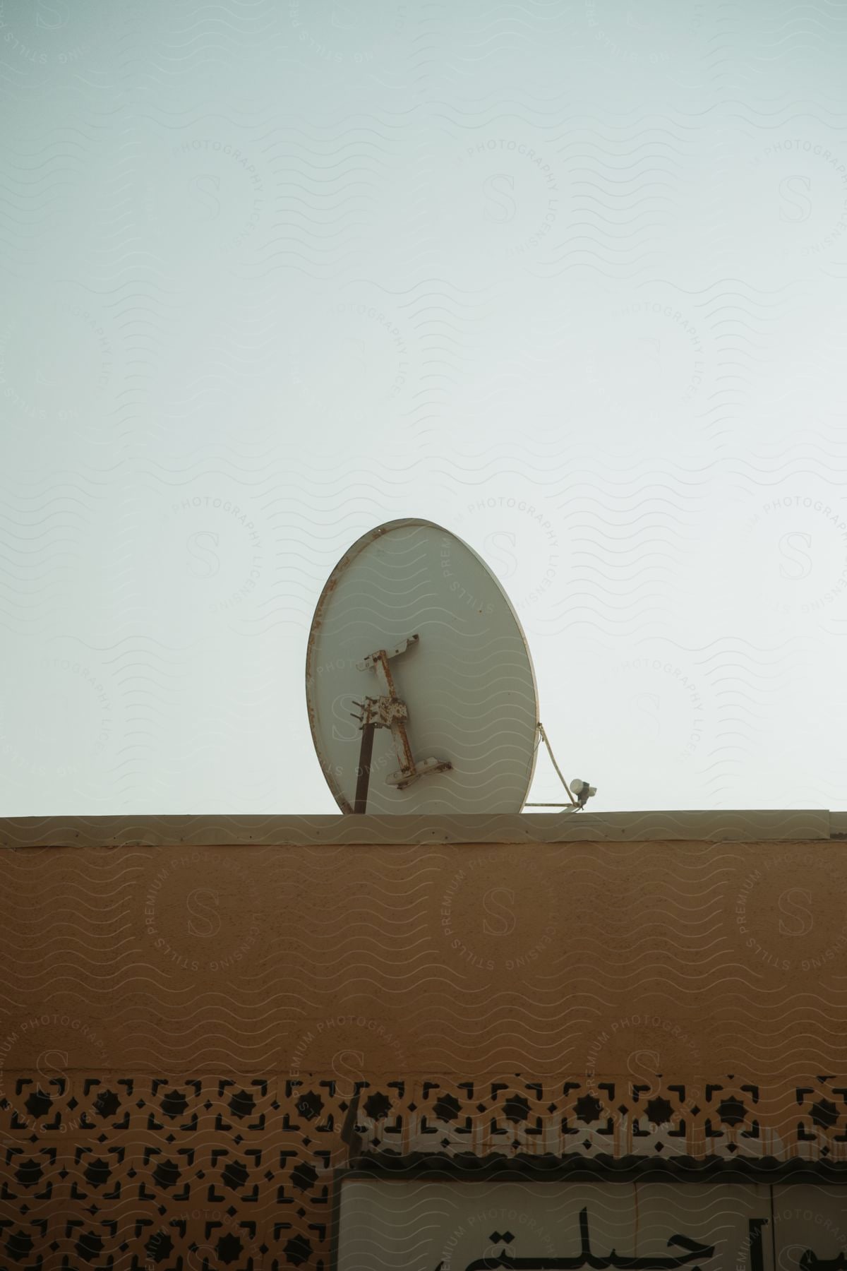 A satellite dish on top of a yellow house.