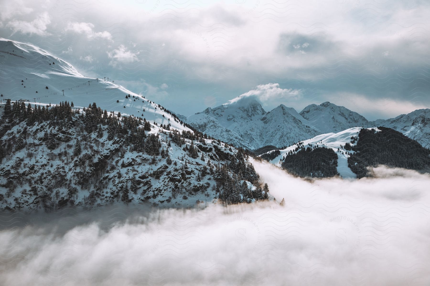 Clouds over a mountain range covered in snow at daytime