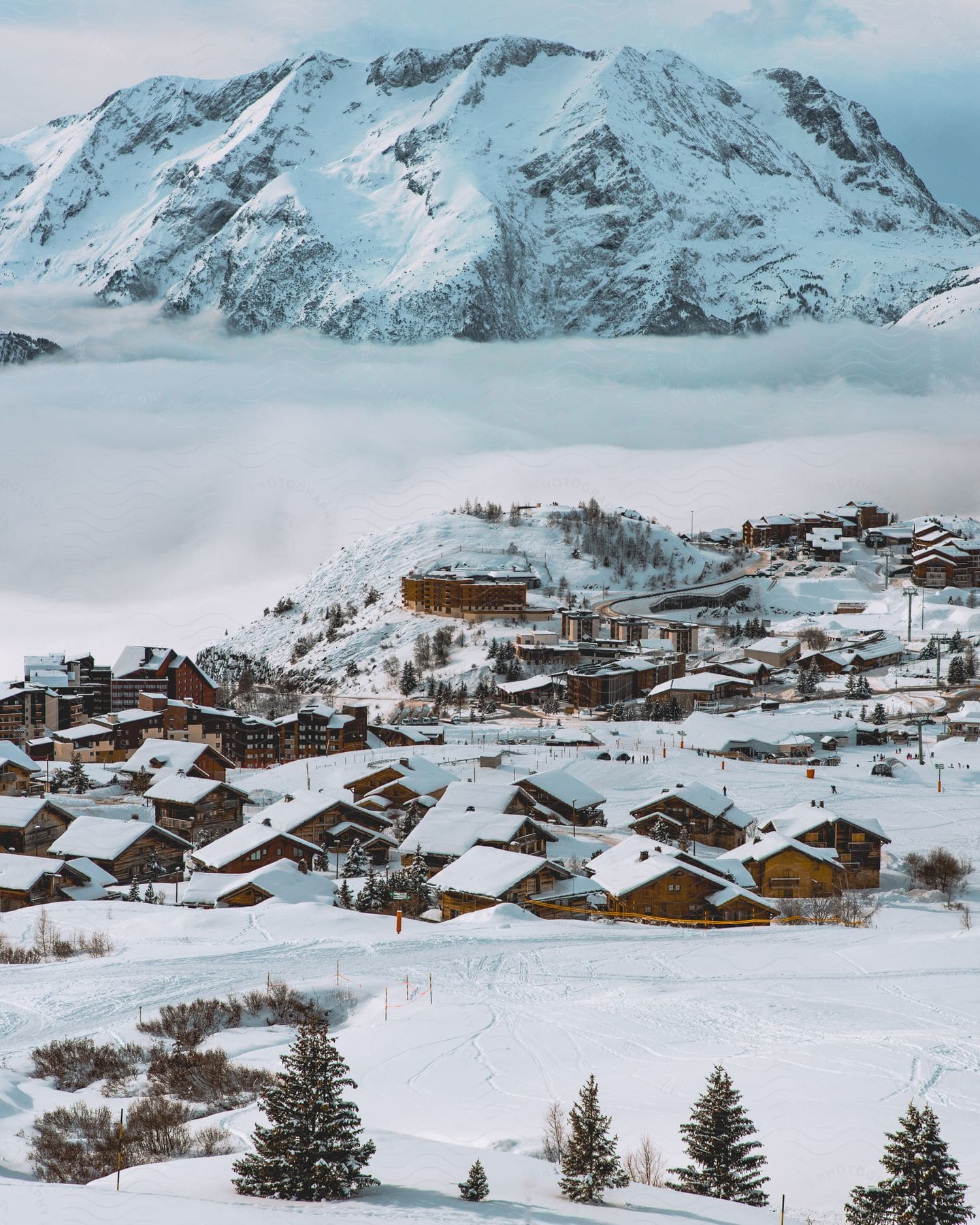 A small village in near a snowy mountain in a snowy environment.