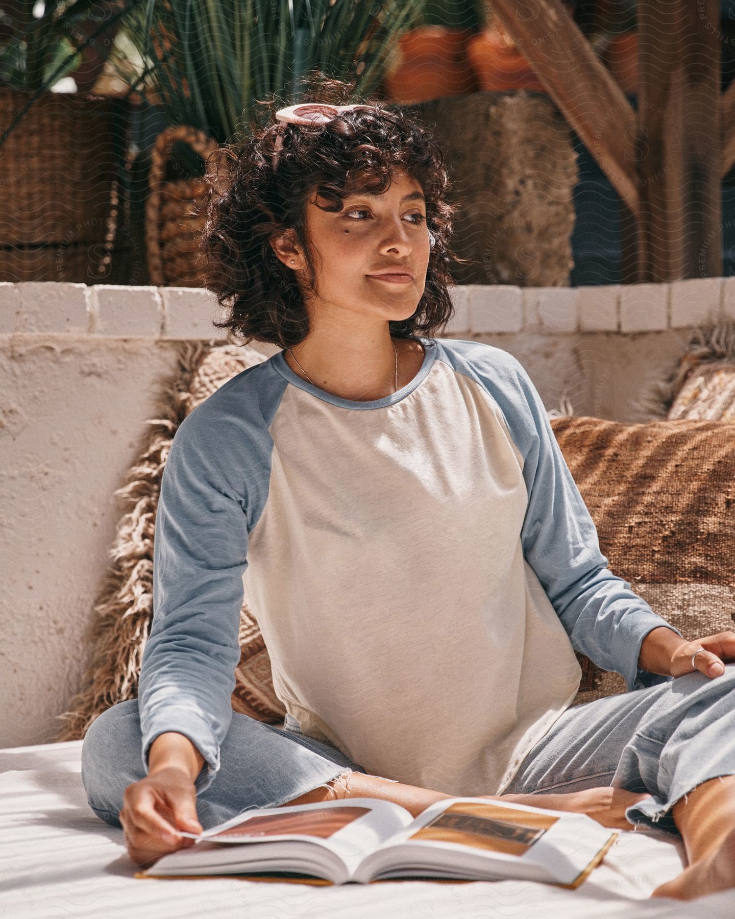 A women is sitting outside and looking off to the side.