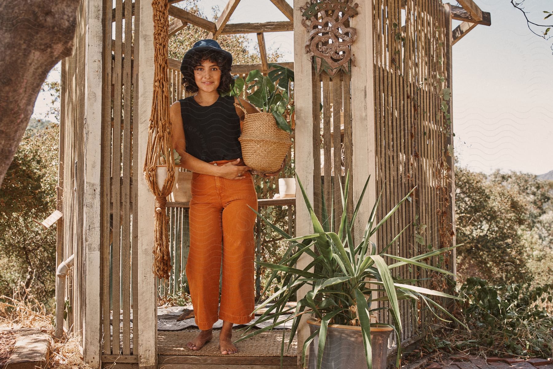 A young woman in a garden with a plant in her hands.