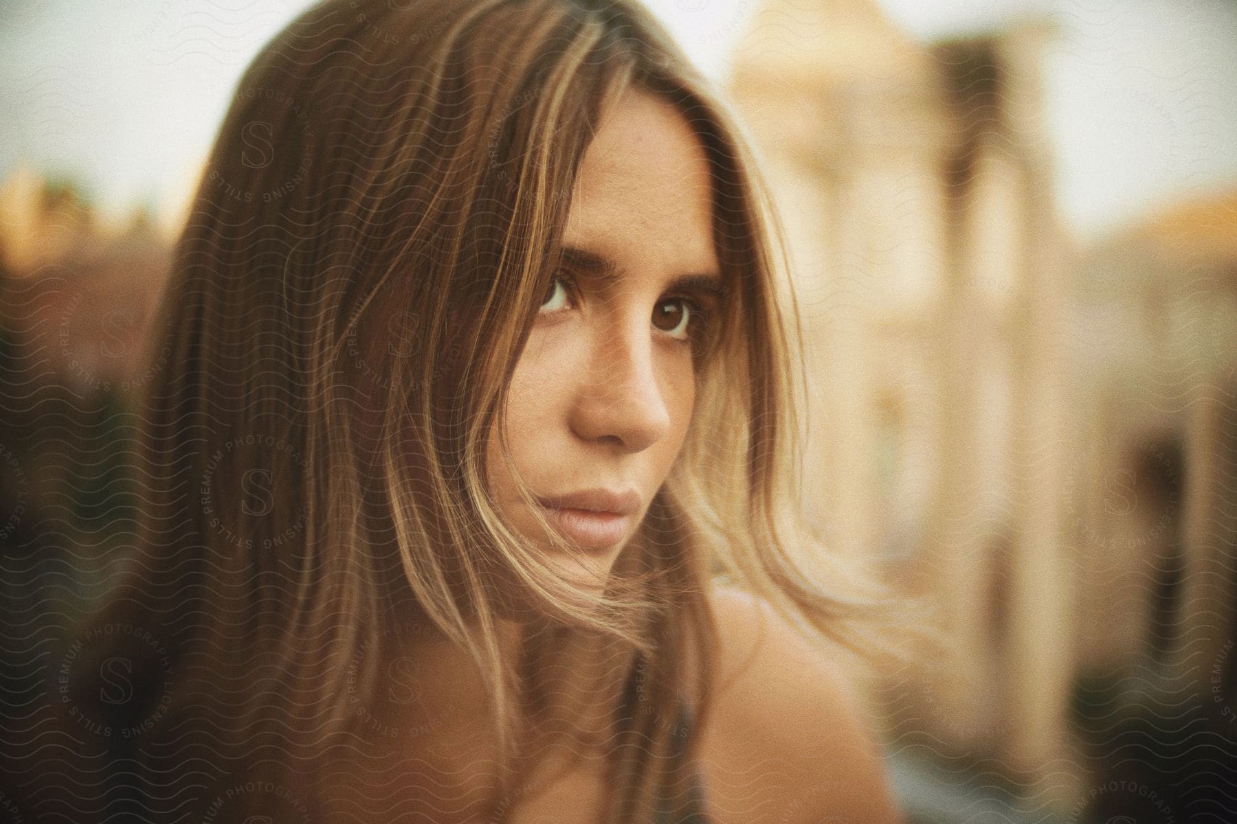 A women with brown eyes and brown hair is looking off into the distance.