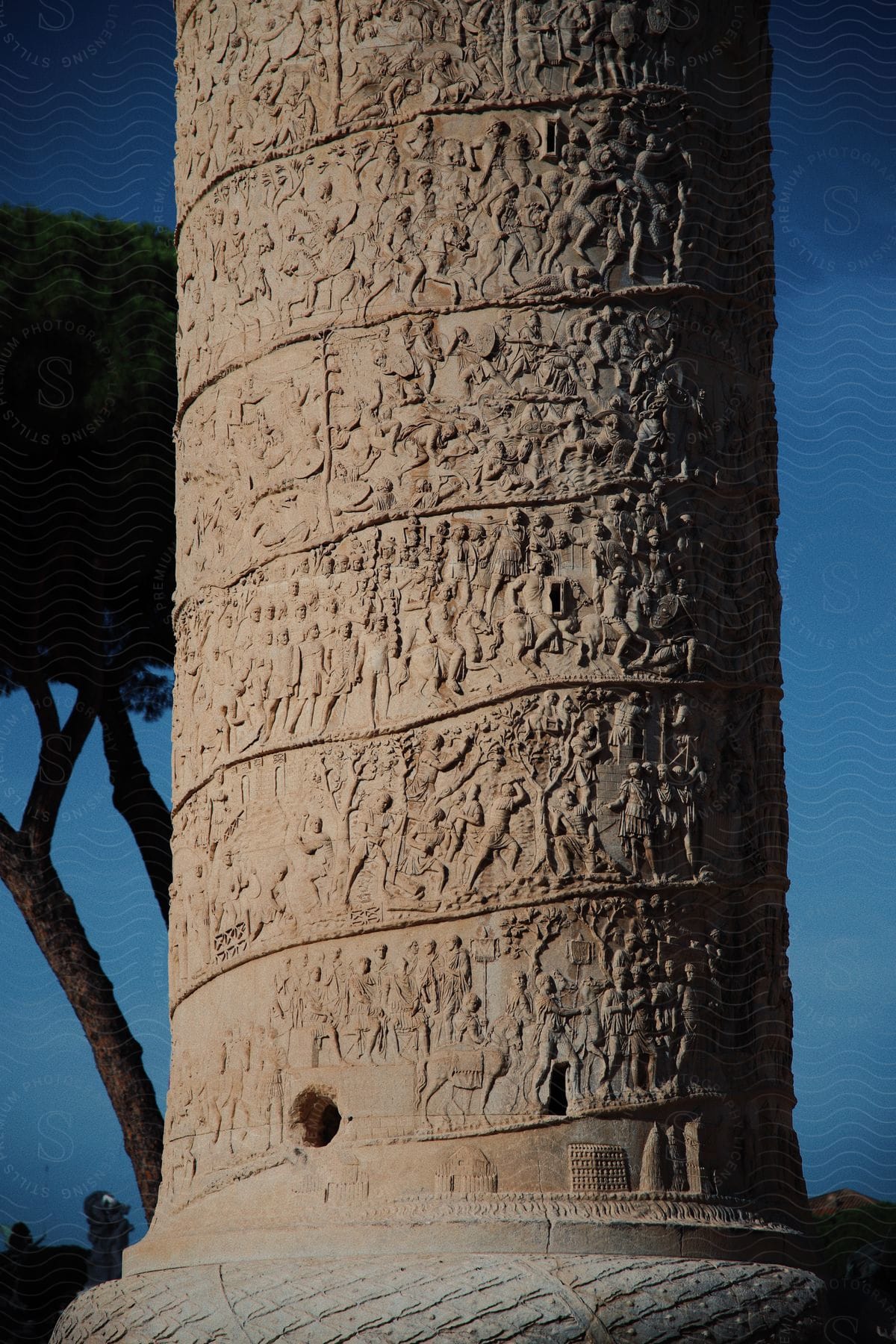 A tall pole-like structure shows several ancient carvings of people and icons from history.