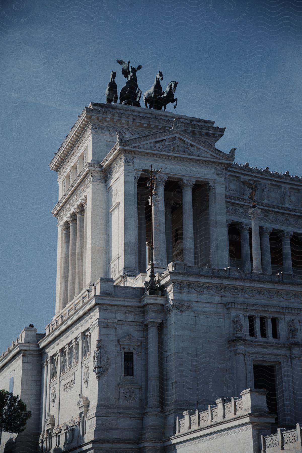 Statues stand on top of an ancient Roman building