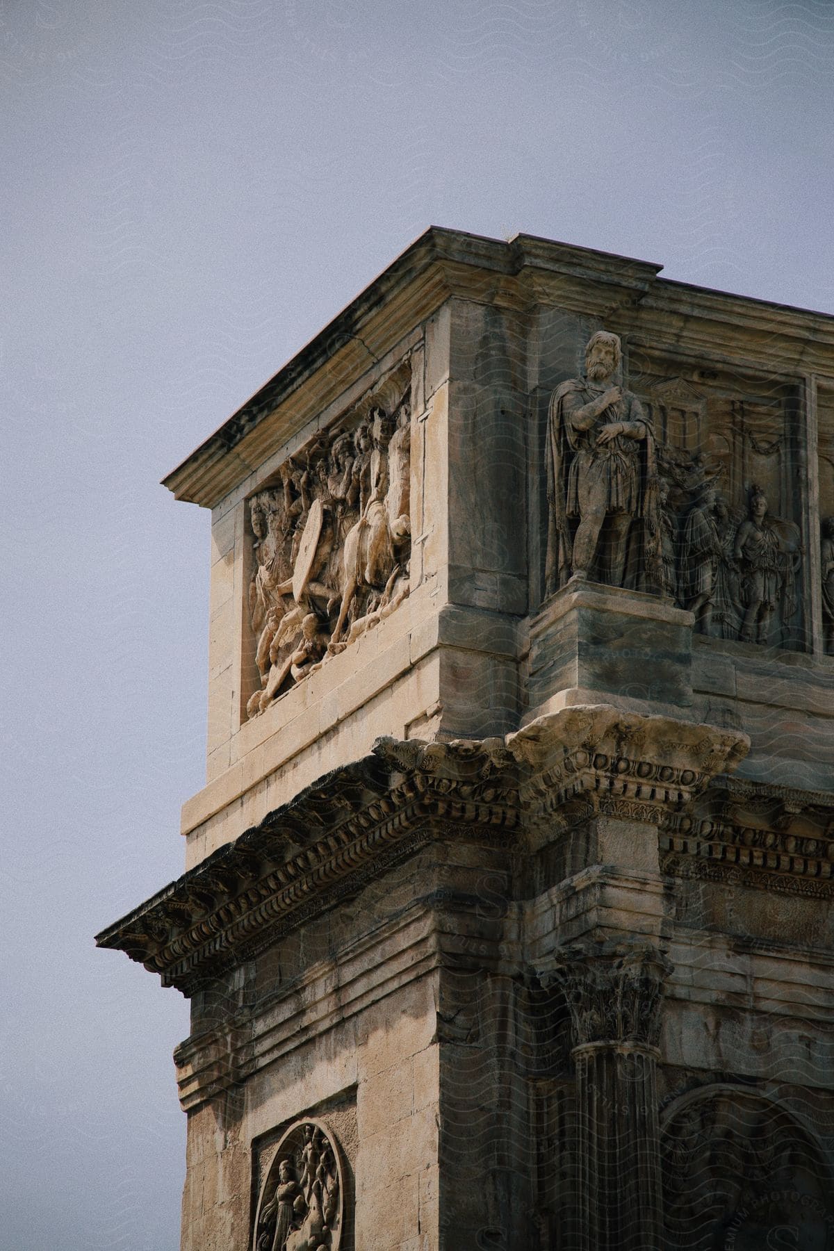 An ancient Roman building with a statue of a man in front.