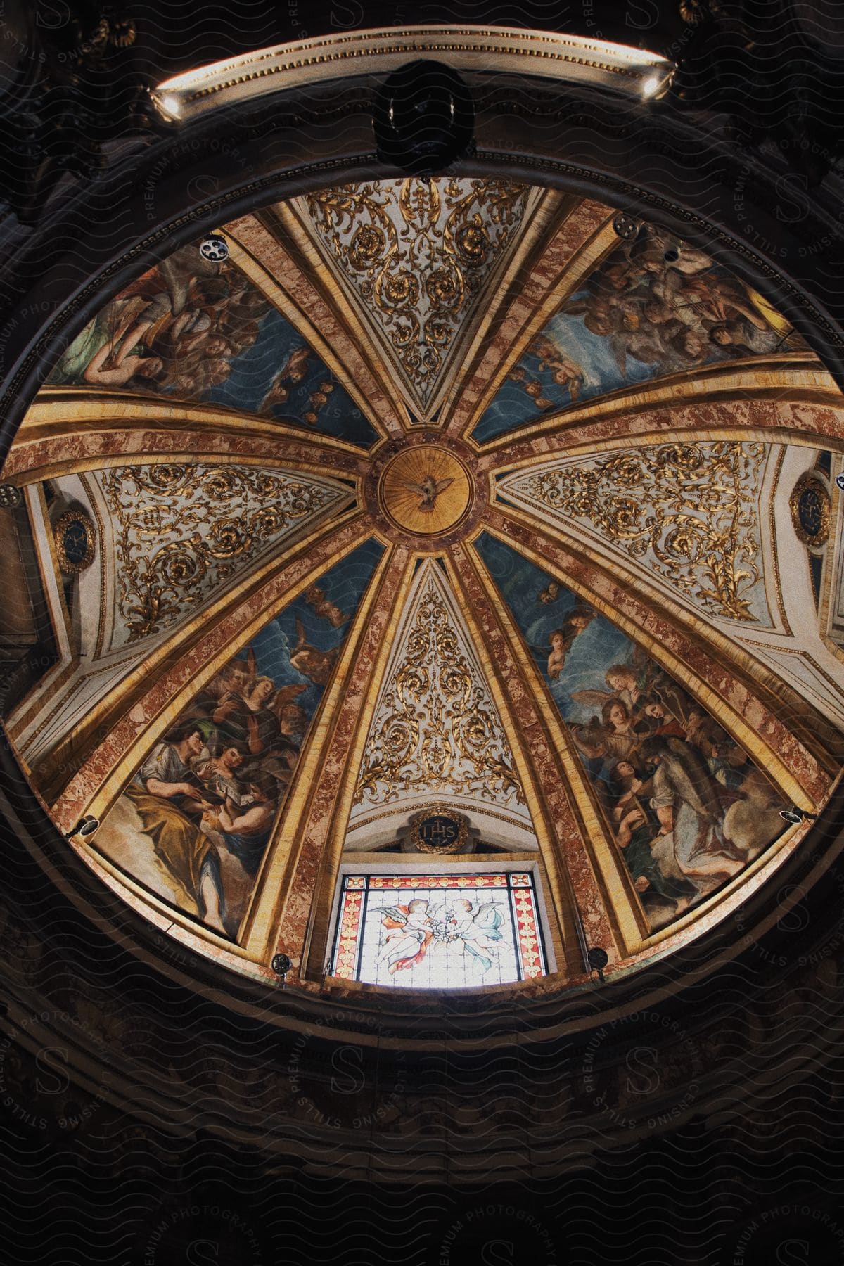 A skylight in a church that is decorated with old paintings.