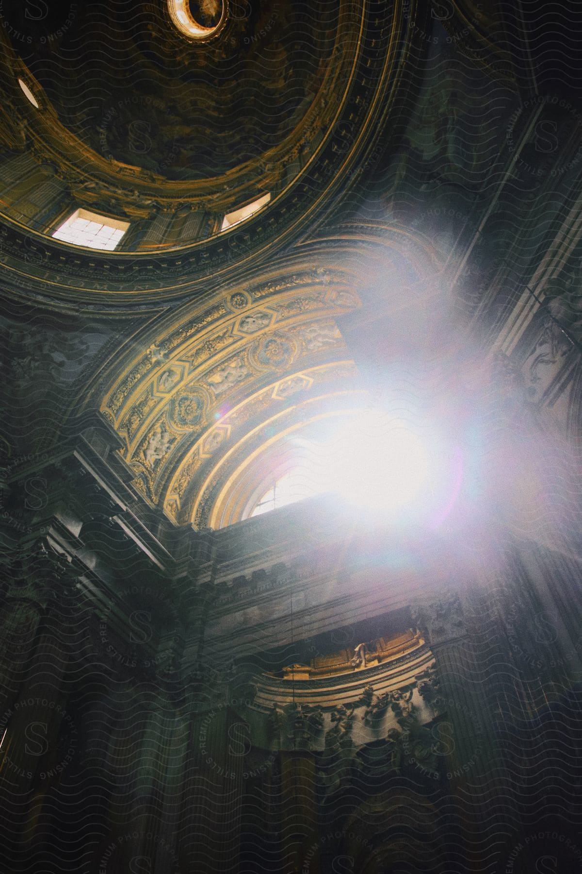 Light shines brightly through a large window within St. Peter’s Basilica in Rome.