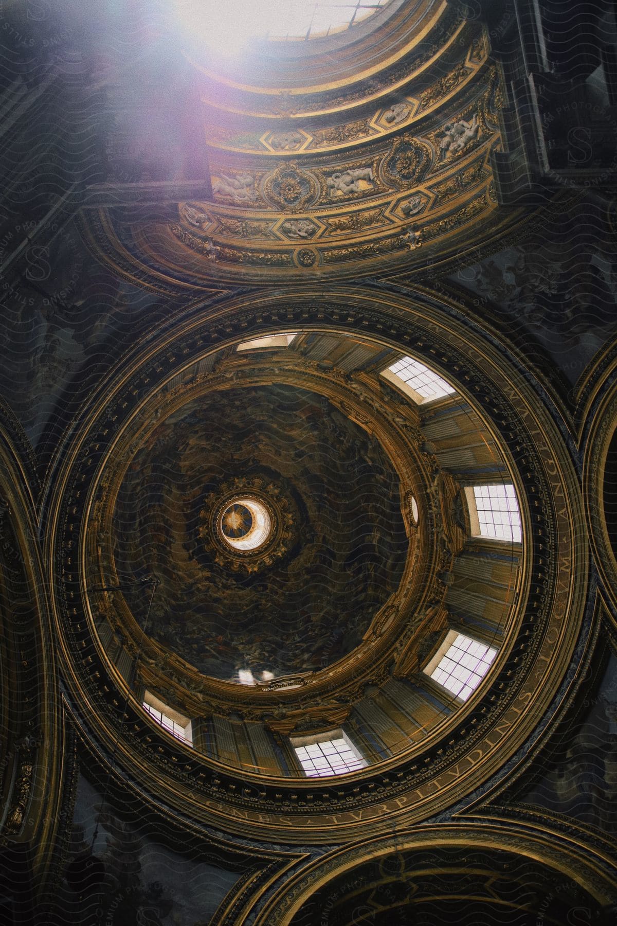 Sun shines into ornately painted and sculpted domed ceiling of historic landmark.