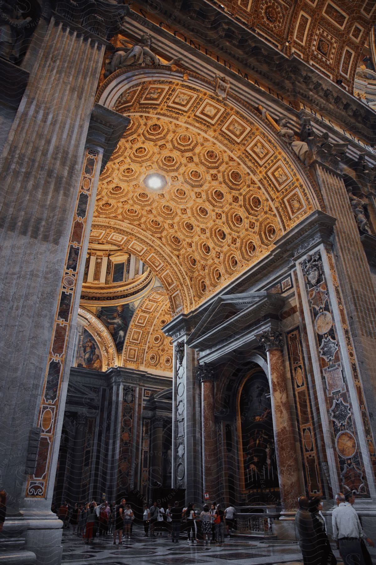 A crowd of tourists view the elaborate artwork and architecture within St. Peter’s Basilica in Rome.