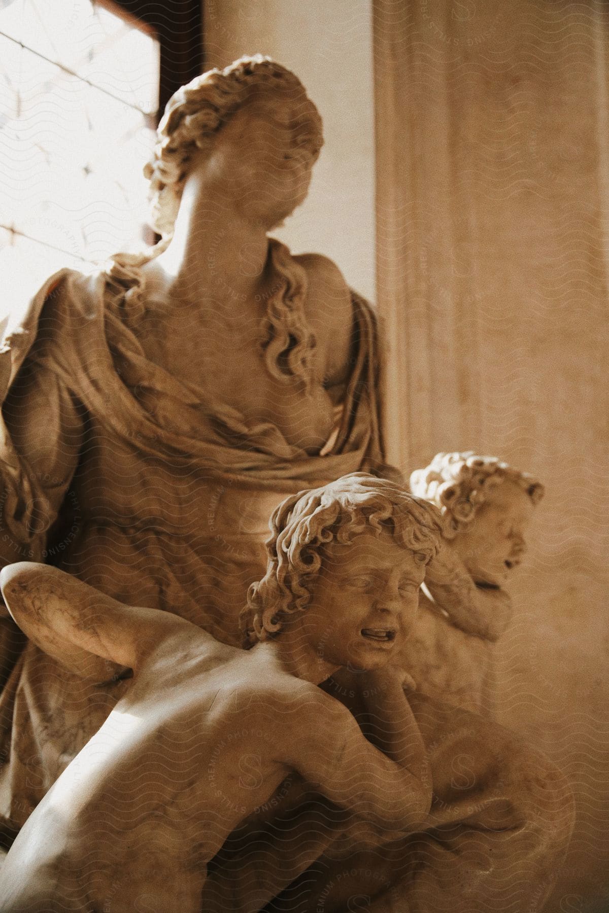 A statue of a woman and children inside of an ancient building.