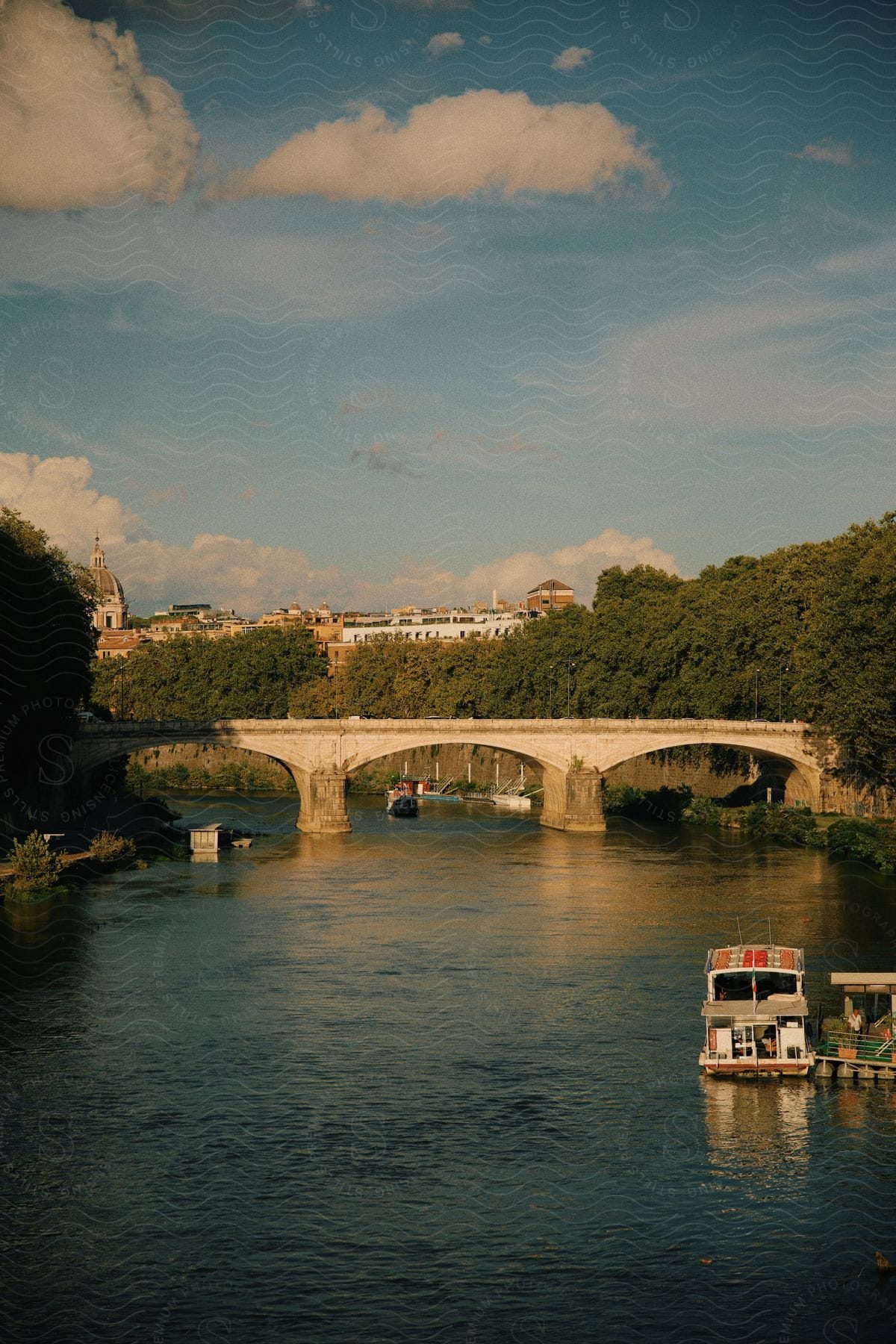 A river with some boats and a bridge that crosses the entire river.