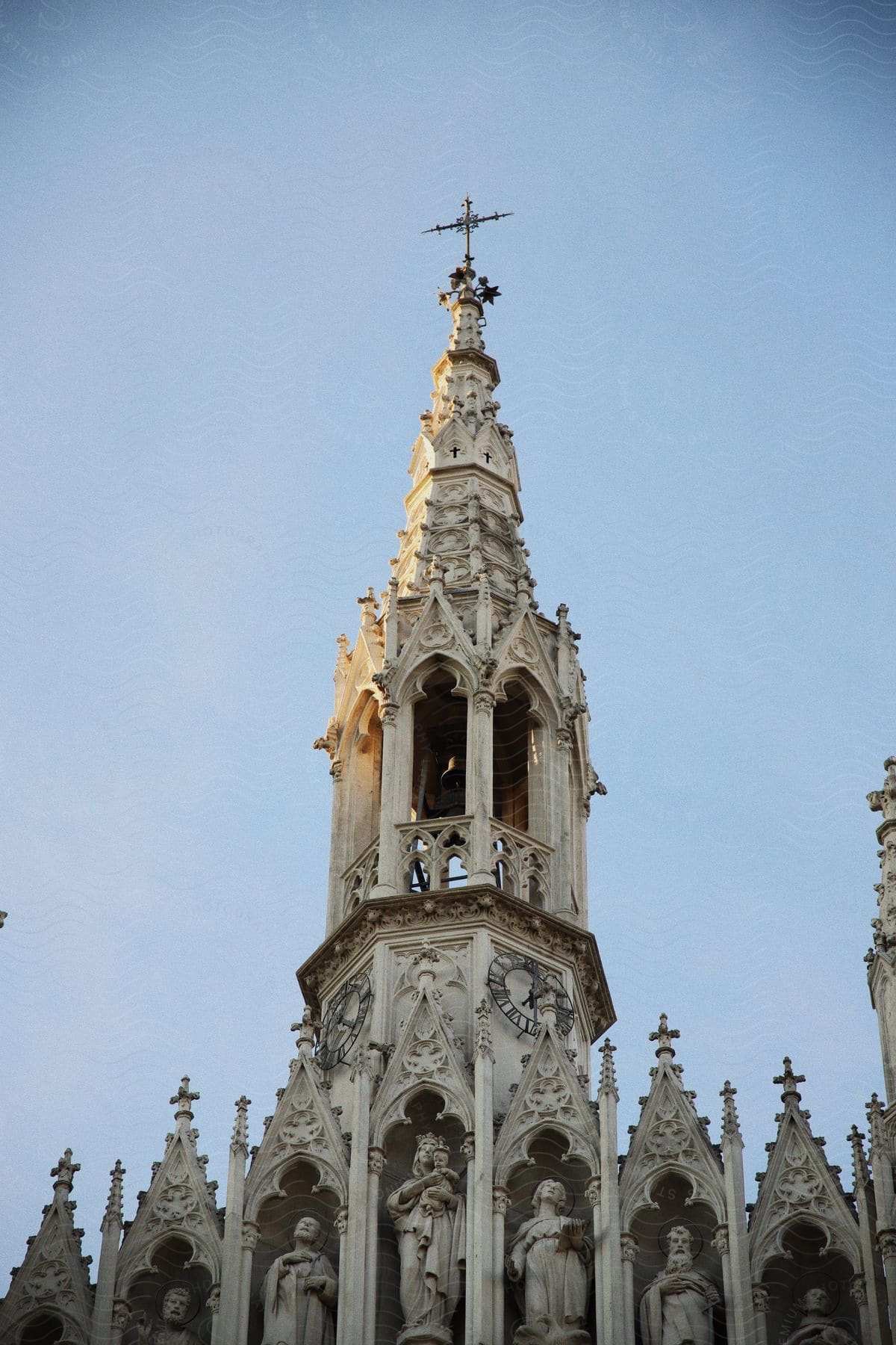 a cross sits atop a narrow tower on a church