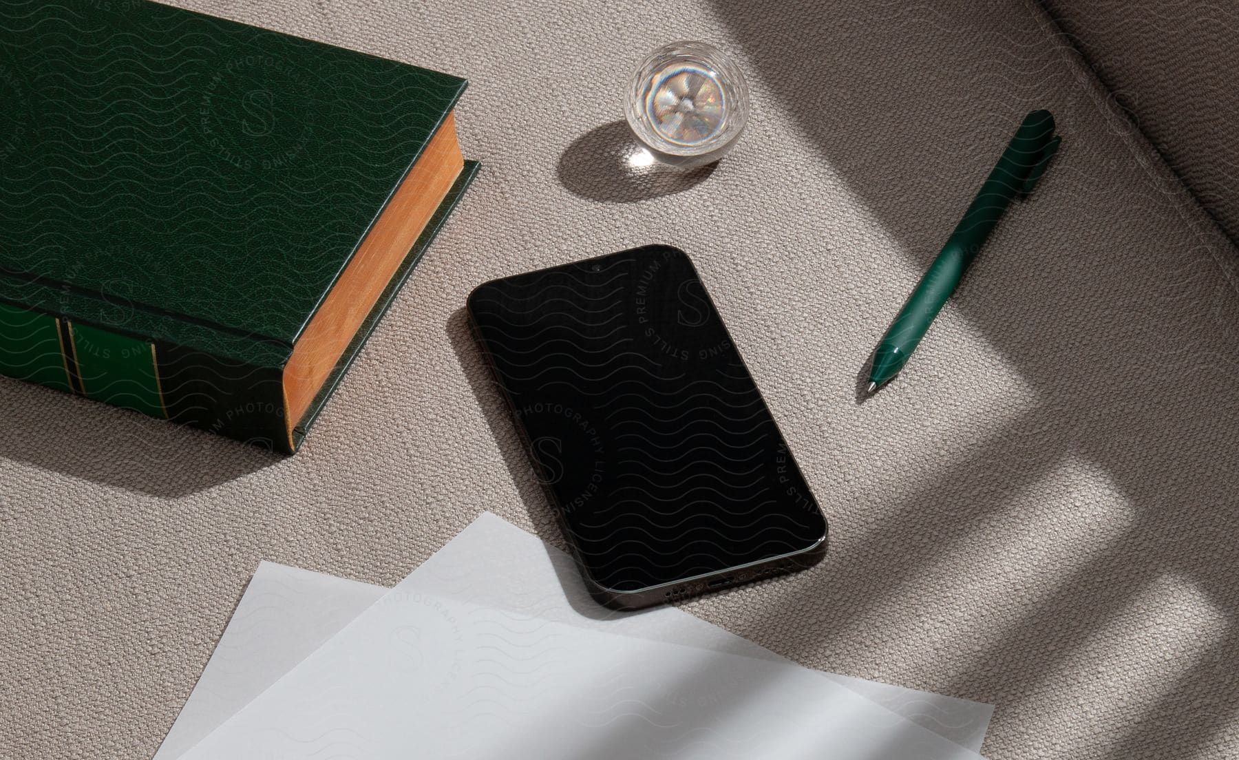 Stock photo of a smartphone is laying on a couch with other items surrounding it.