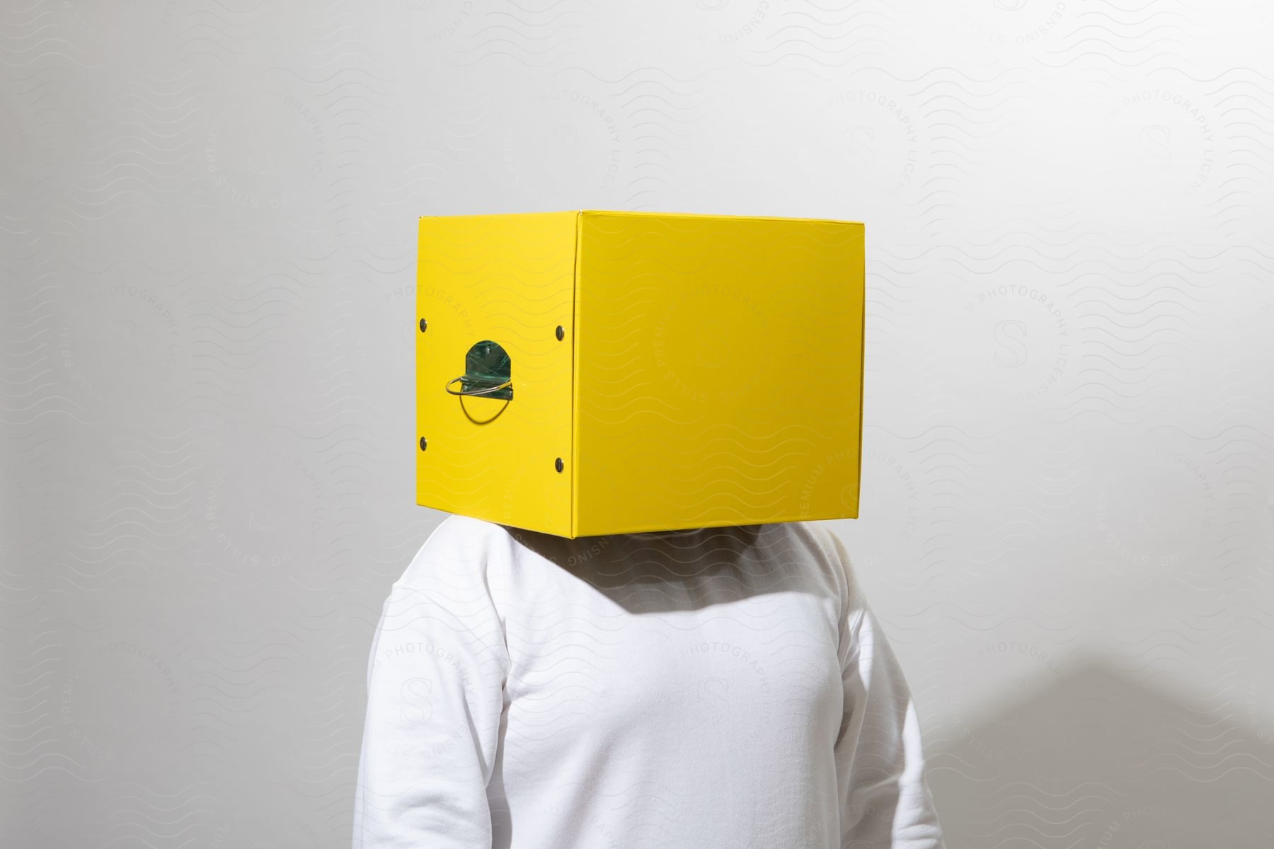 A person performing with a yellow box on their head.