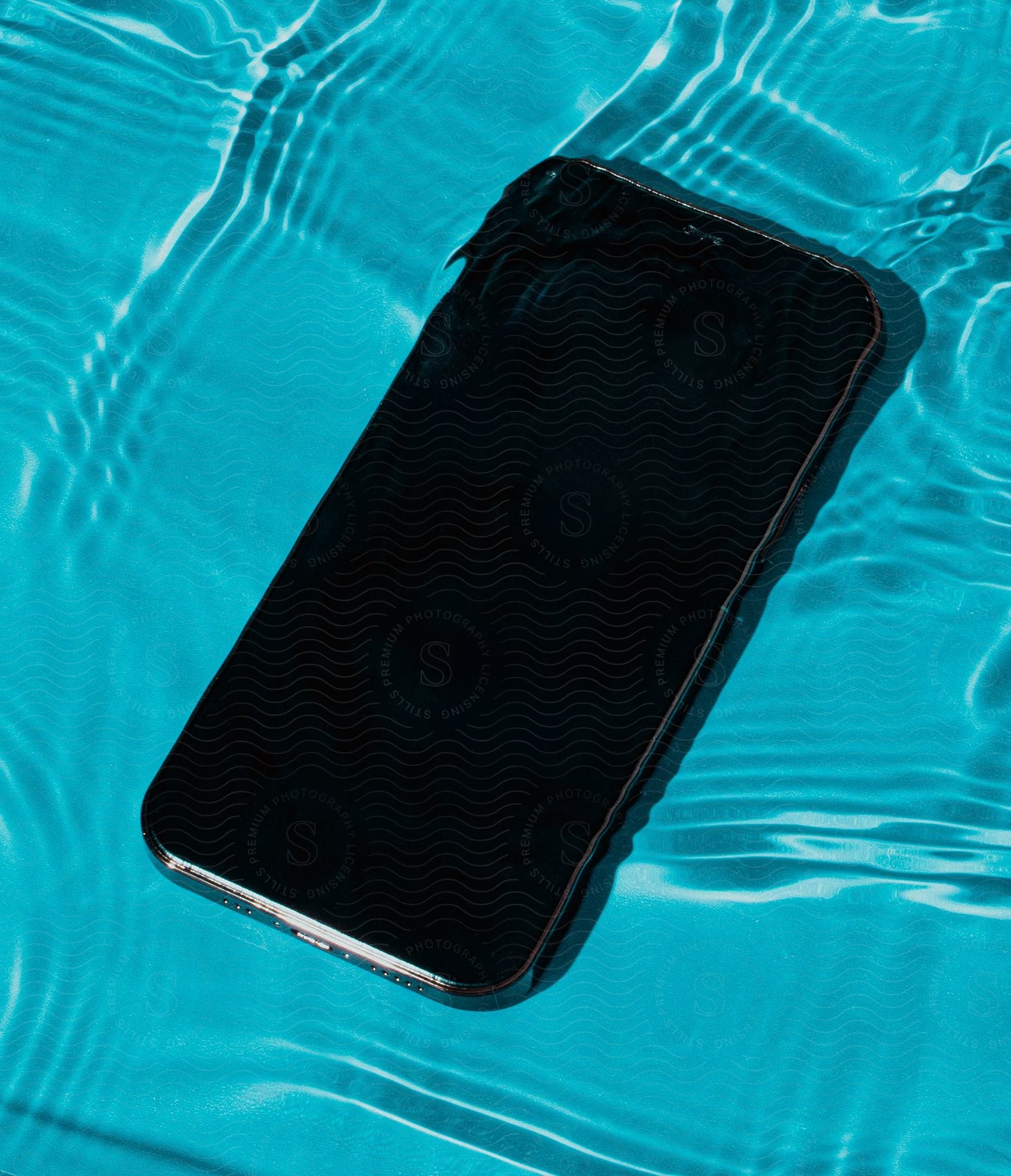 A phone sitting on top of some water in a pool.