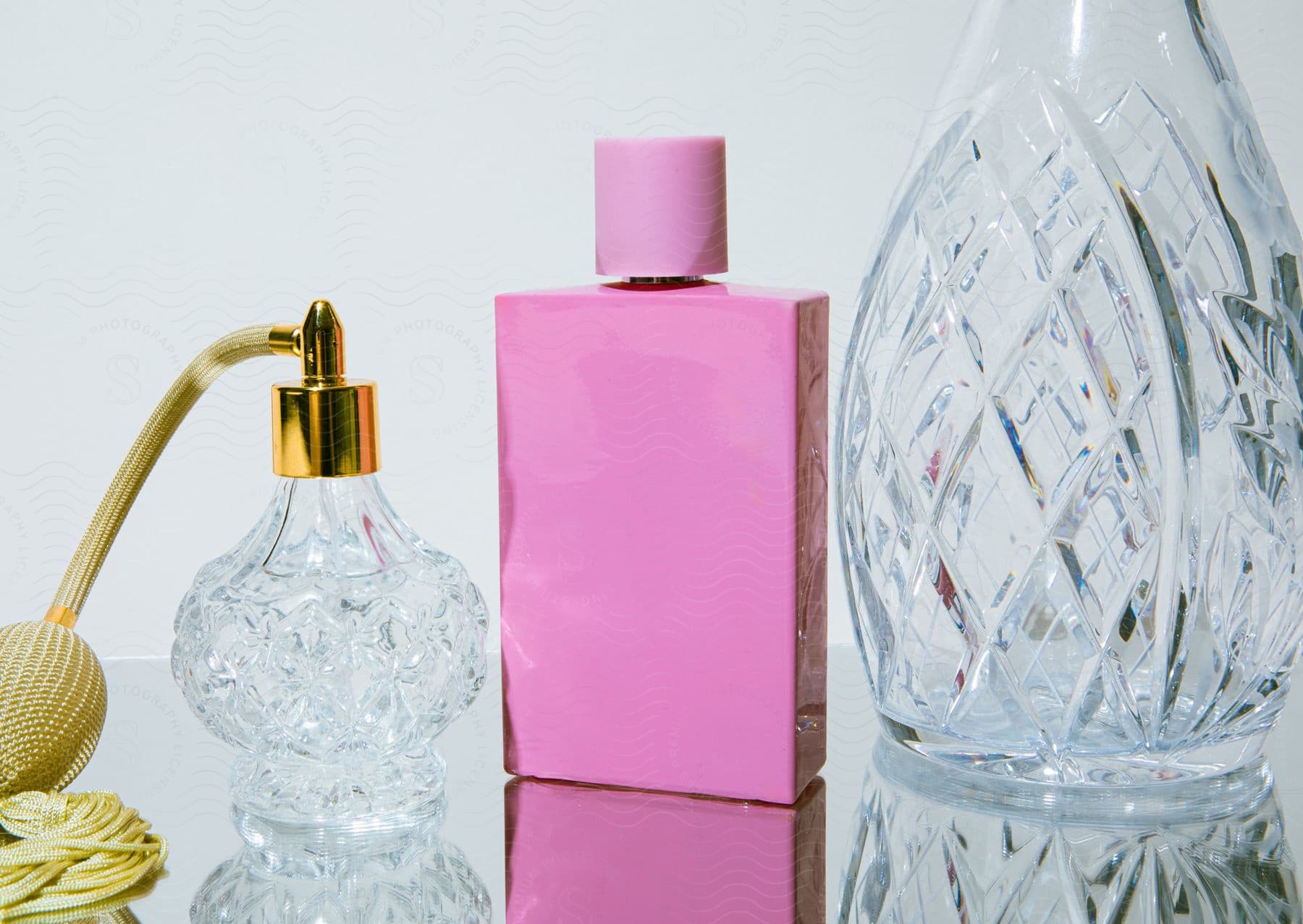 Perfume bottles sit on reflective surface.