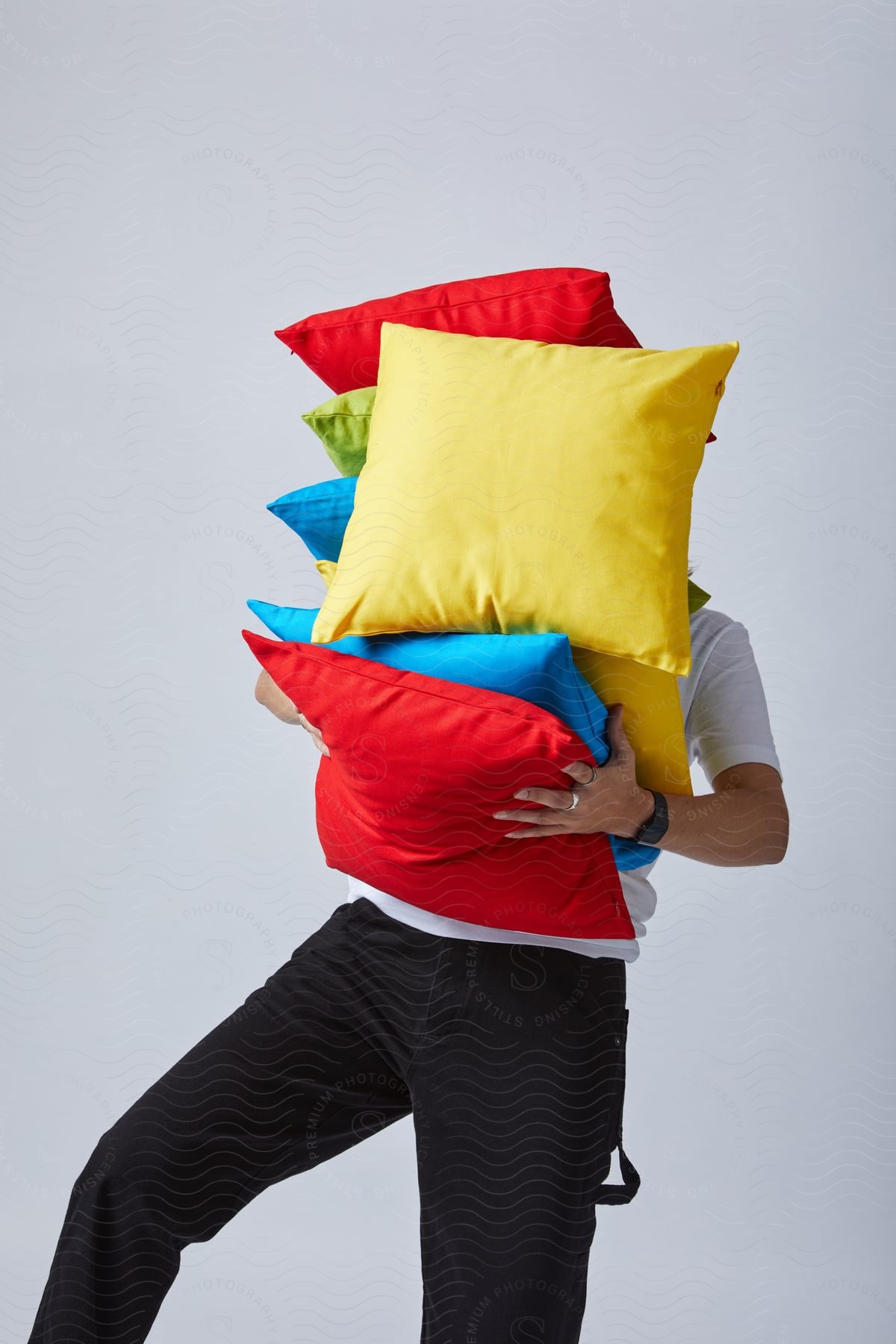 A man carrying some pillows in a store