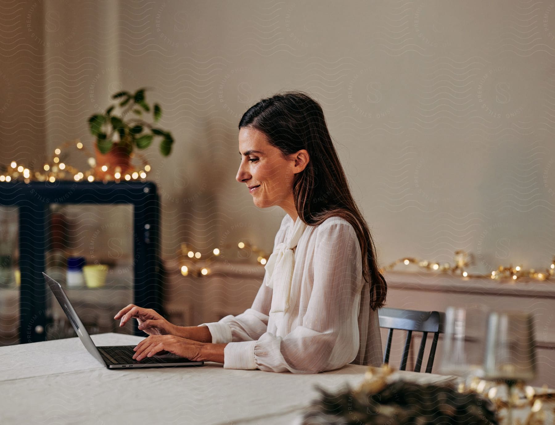 A woman sitting down at a table using a laptop.