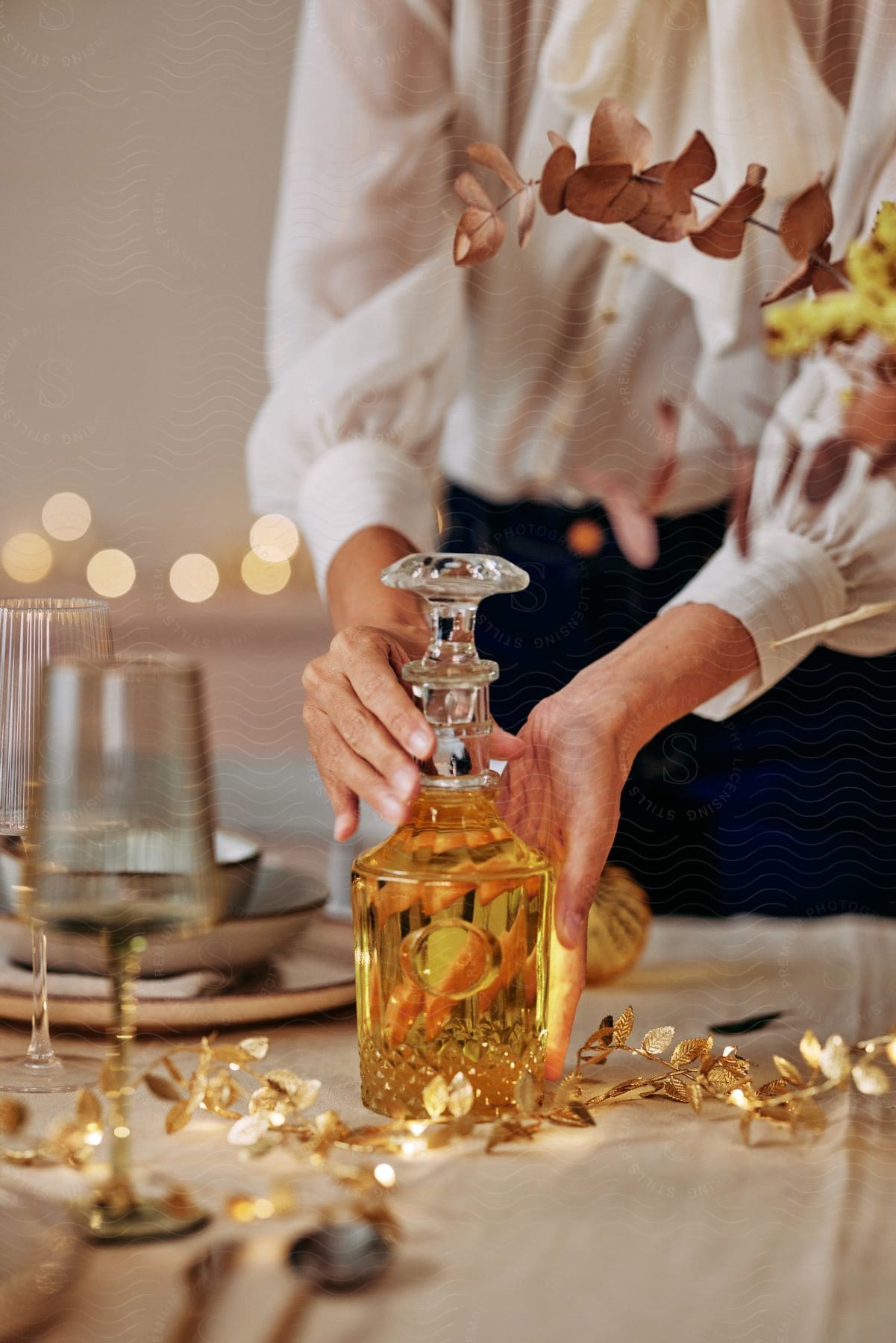 A woman placing a bottle of alcohol on a table.