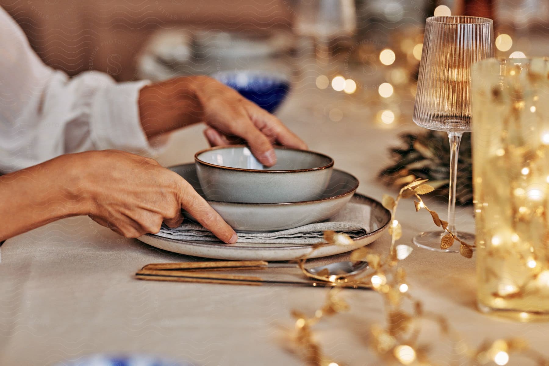 Stock photo of woman wearing a white shirt sits at long table holds a bowl and plate