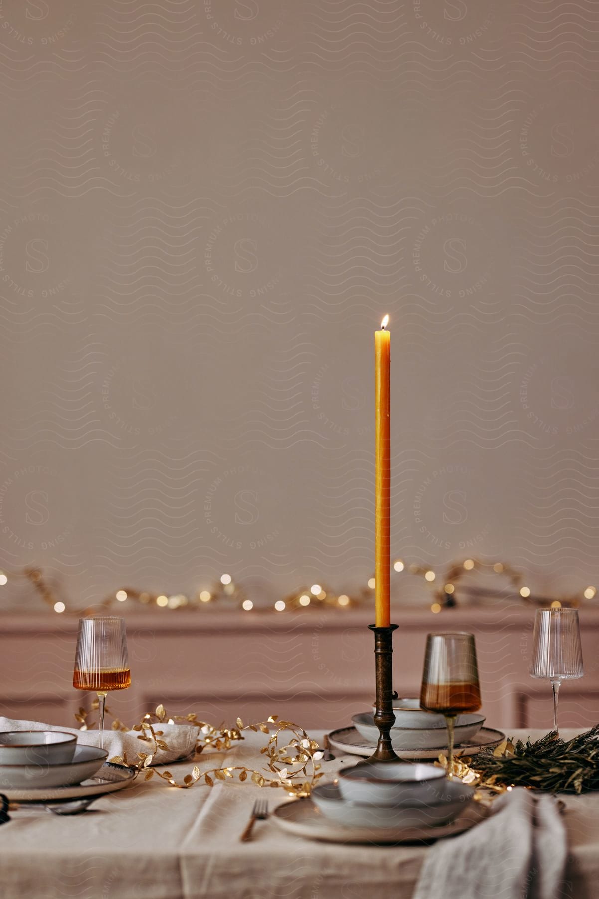 A candle sitting on a table with some dishes.