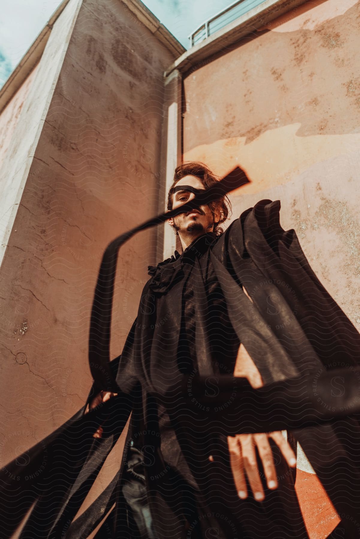 Stock photo of a young man in black clothes wearing an eye patch.