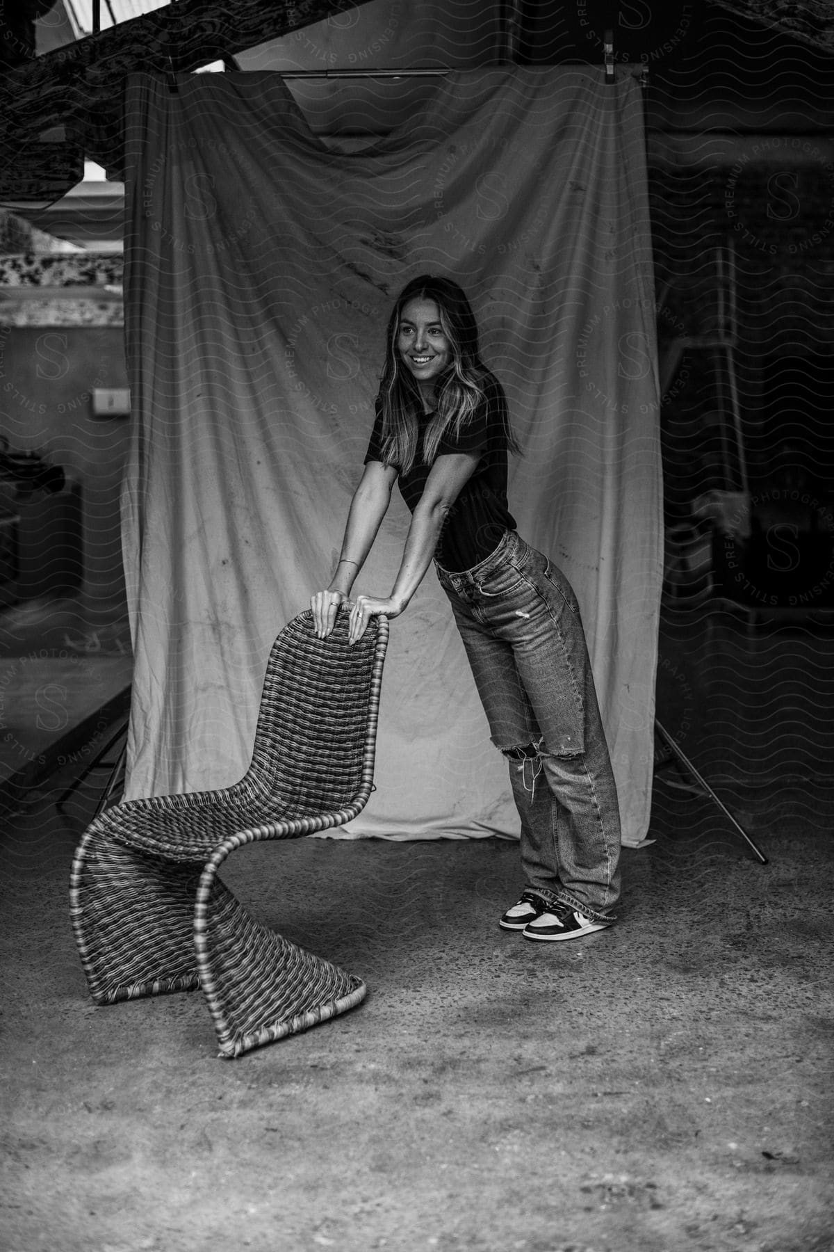 Young woman modeling with her hands resting on a chair.